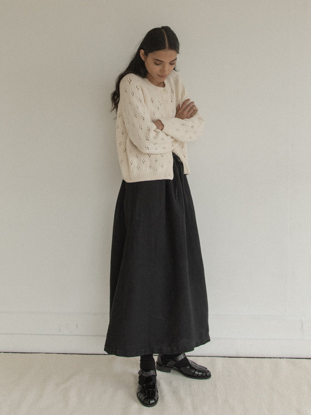 Model wearing the Mabel Cardigan in Ivory by Gillian Stevens, full-length front view with arms crossed