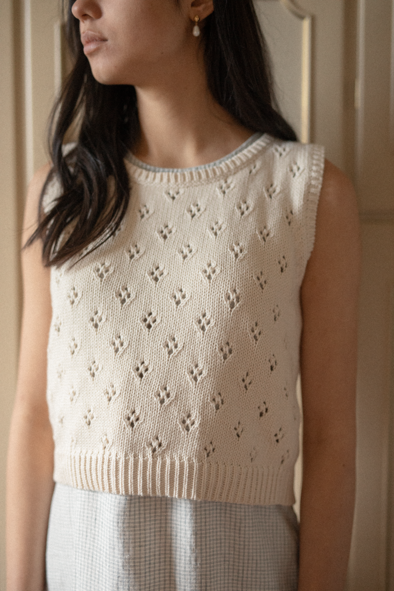 Model wearing the Niah Top in Ivory by Gillian Stevens, close-up showing the pointelle knit pattern and ribbed hem