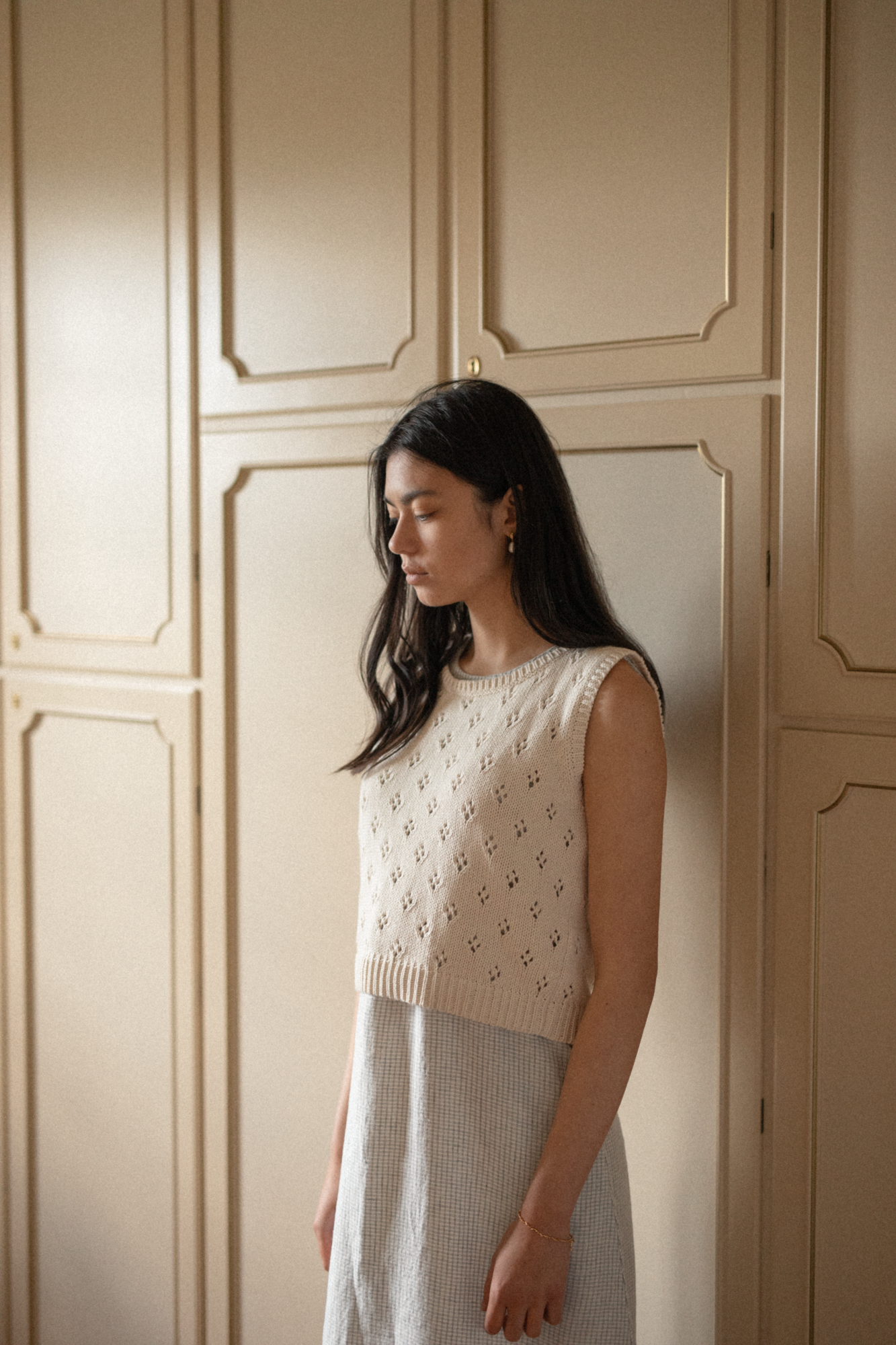 Model wearing the Niah Top in Ivory by Gillian Stevens, side view showing pointelle knit detail