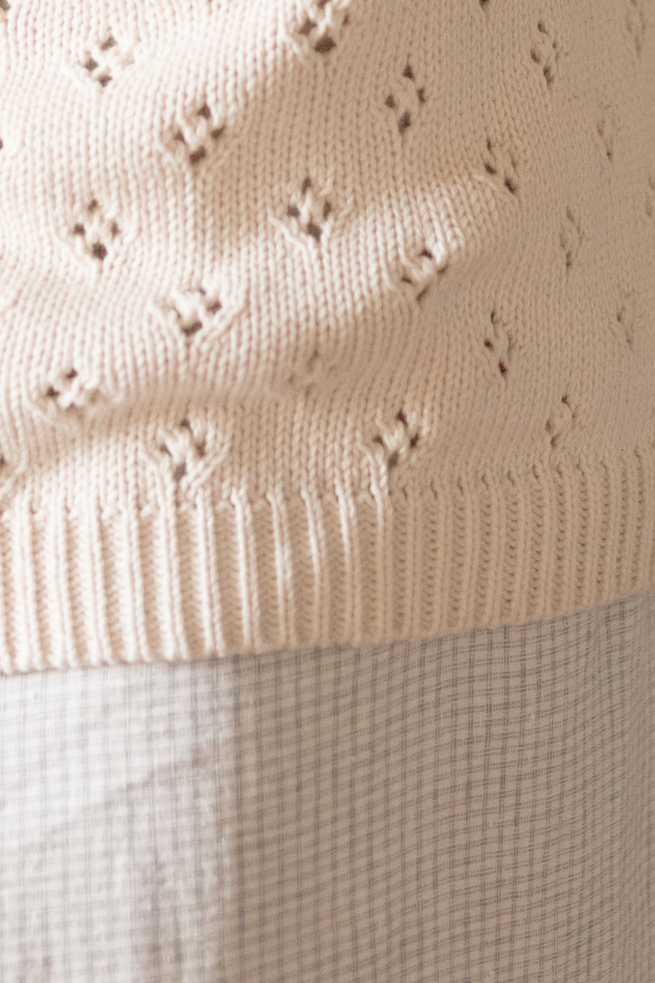 Close-up of the Niah Top in Ivory by Gillian Stevens, showing the pointelle knit pattern and ribbed hem
