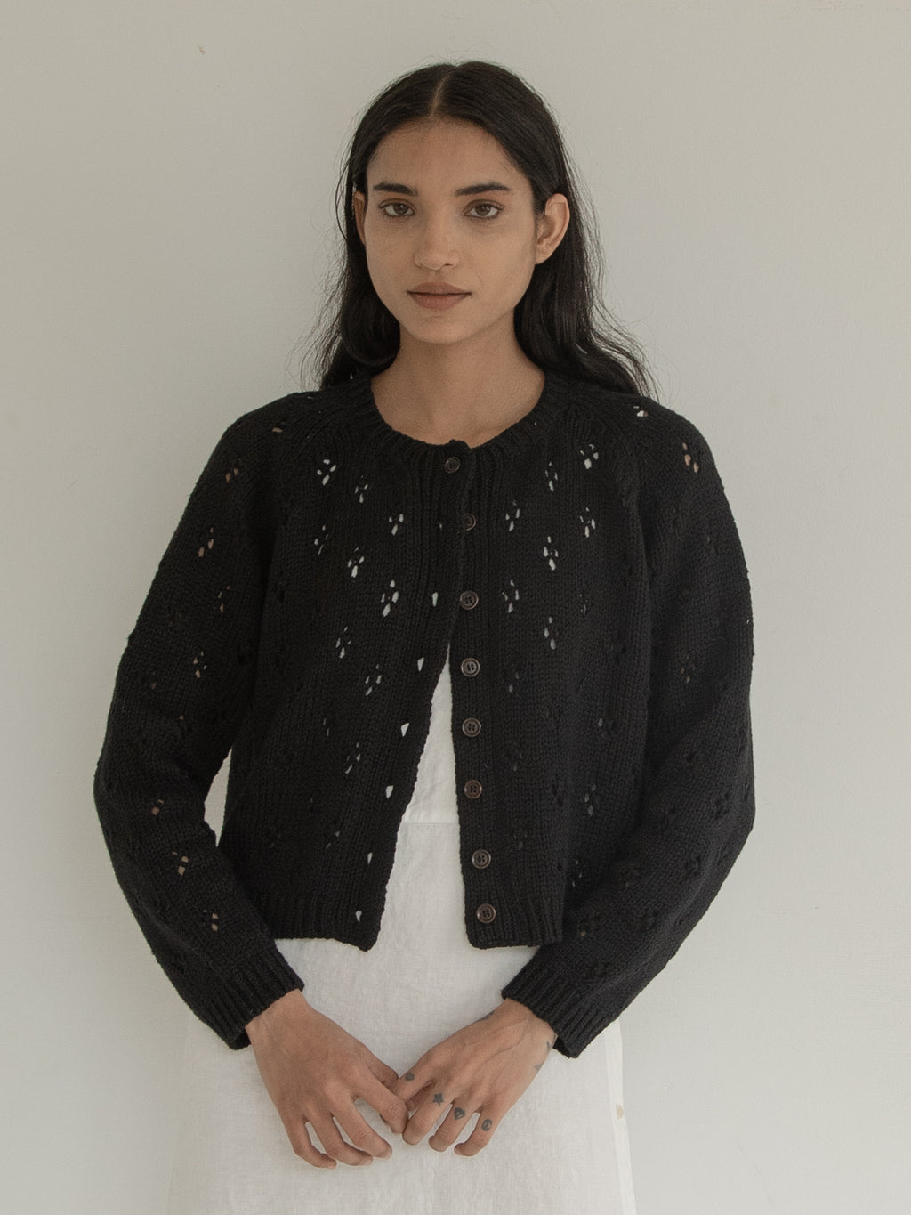 Model wearing the Mabel Cardigan in Noir by Gillian Stevens, front view showing openwork knit detail