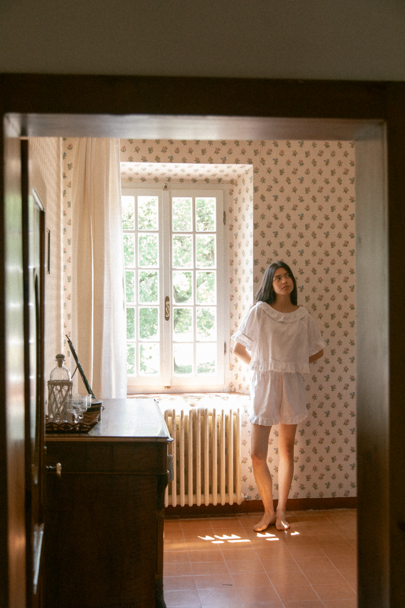 Model wearing the Arlette Short in Salt by Gillian Stevens, full-length view in a sunlit vintage room