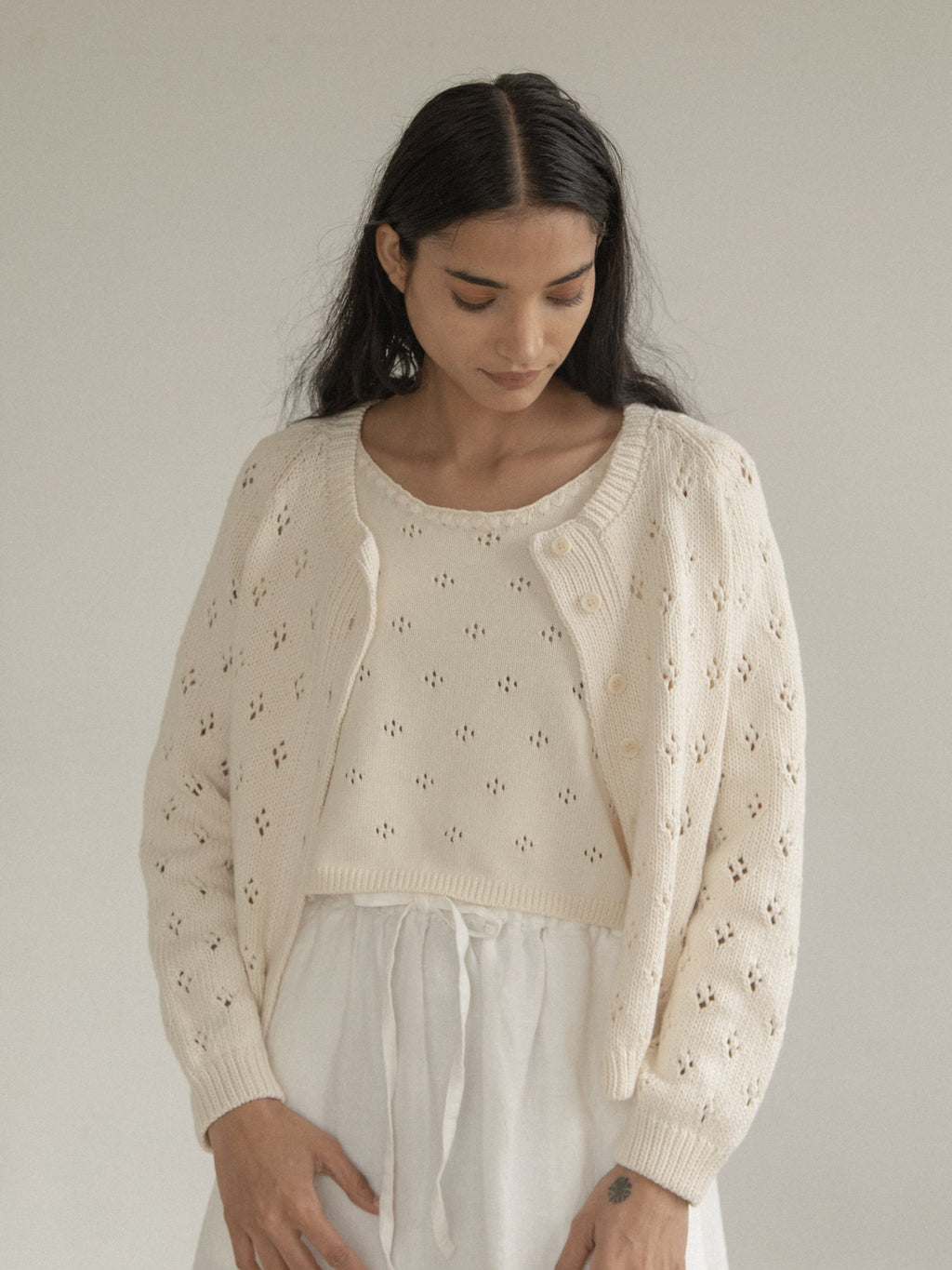 Model wearing the Mabel Cardigan in Ivory by Gillian Stevens, front view showing pointelle detail