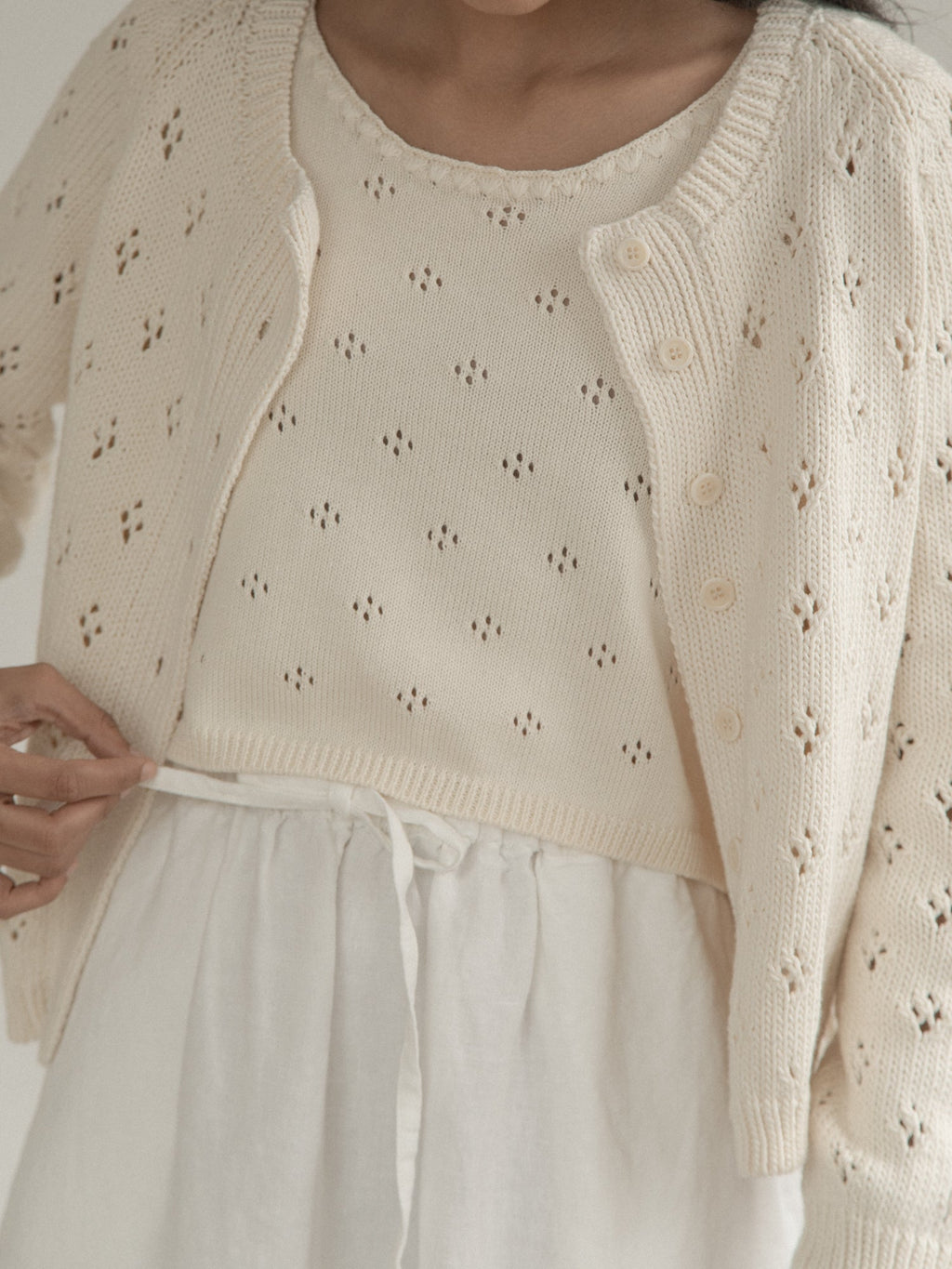 Close-up of the Mabel Cardigan in Ivory by Gillian Stevens, showing pointelle knit and button detail