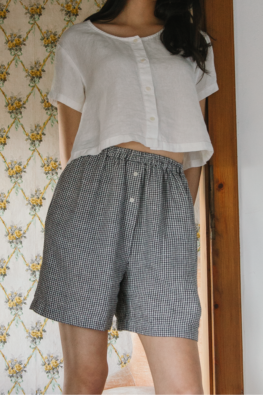 Model wearing the Sally Shorts in Marine Gingham by Gillian Stevens, front view showing elastic waist and check pattern