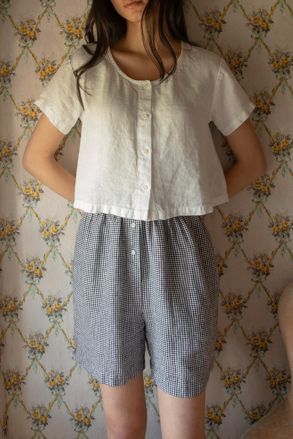 Model wearing the Sally Shorts in Marine Gingham by Gillian Stevens, front view styled with a cropped linen top