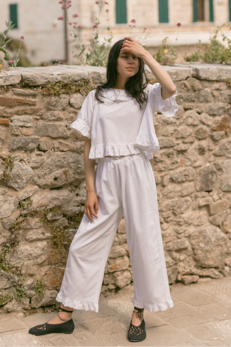 Model wearing the Arlette Pant in Salt by Gillian Stevens, front view styled with matching ruffle top outdoors