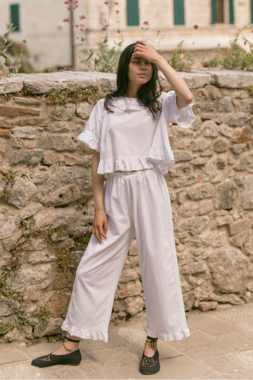Model wearing the Arlette Pant in Salt by Gillian Stevens, front view styled with matching ruffle top outdoors
