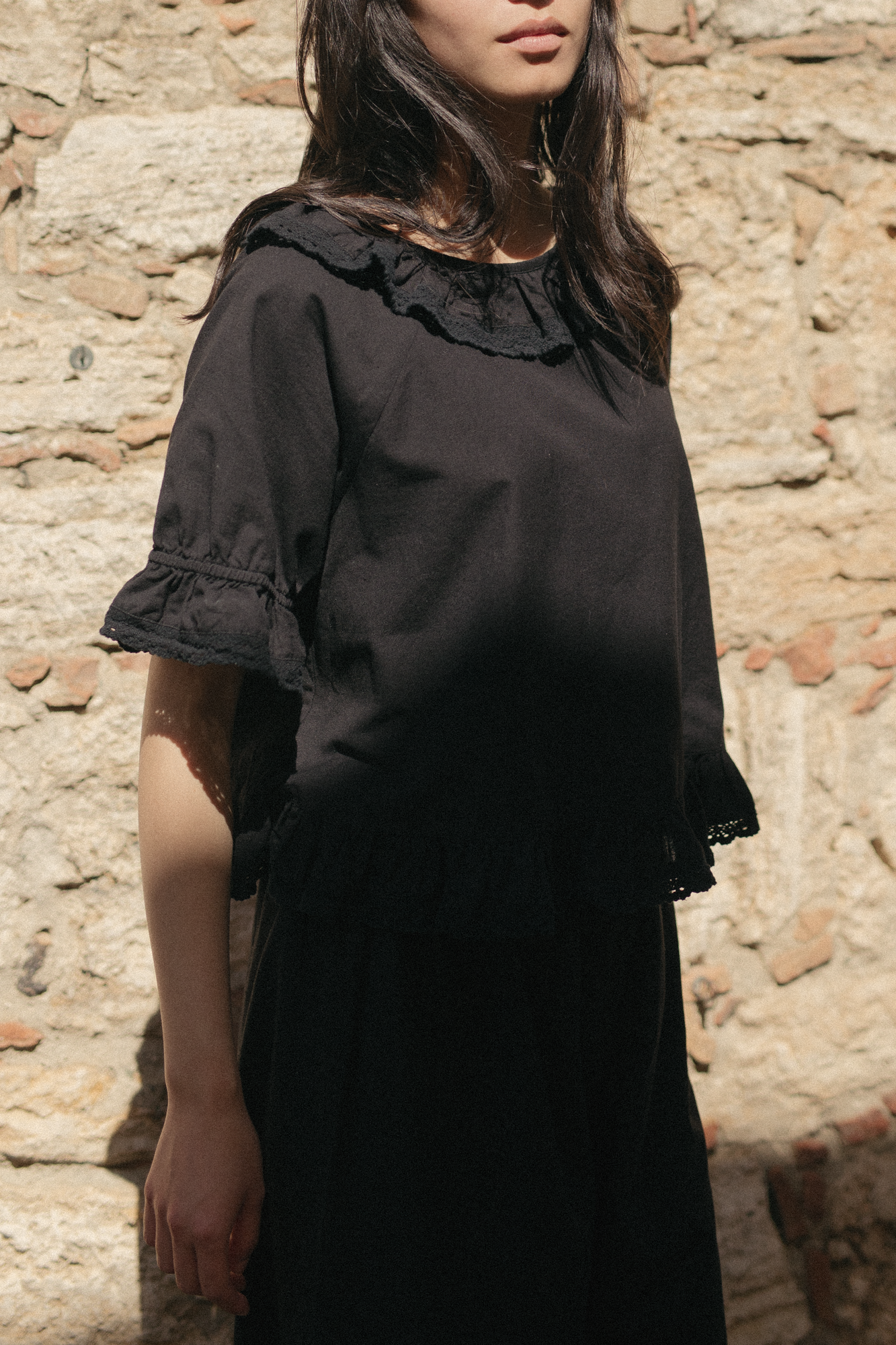 Model wearing the Arlette Top in Noir by Gillian Stevens, front view showing lace collar and ruffle cuffs