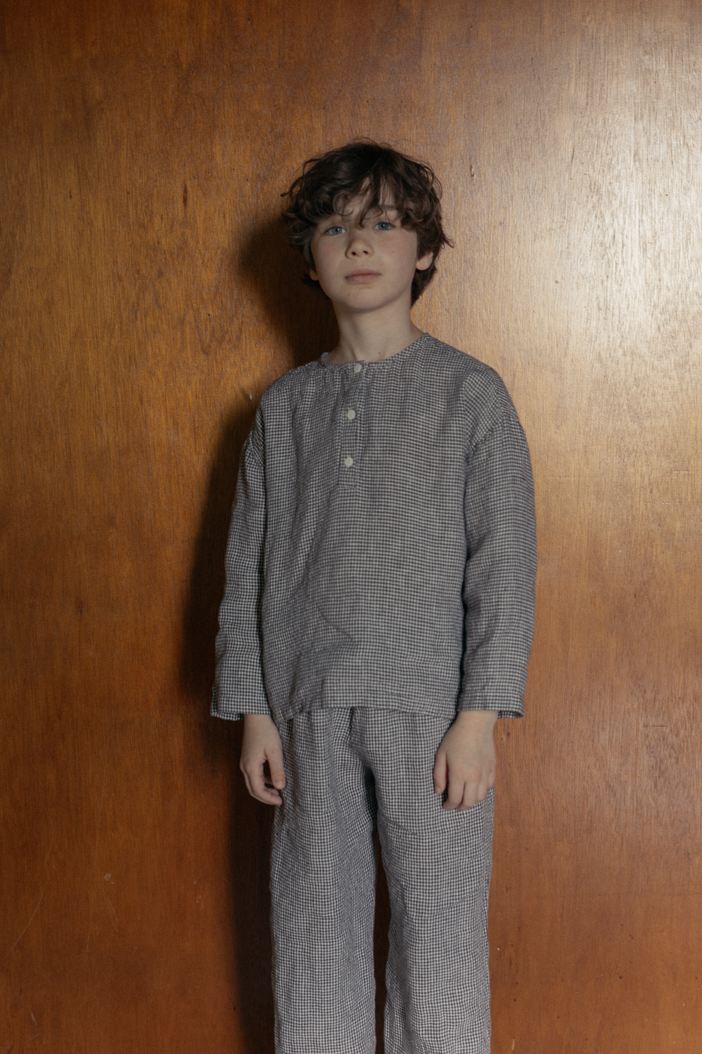 Child wearing the Bertie Top in Espresso Gingham by Gillian Stevens, front view styled with matching pants
