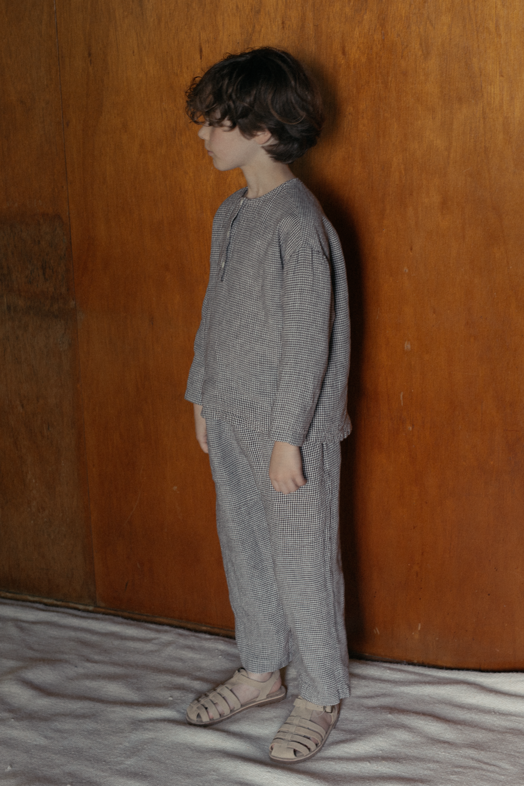 Child wearing the Bertie Top in Espresso Gingham by Gillian Stevens, side view styled with matching pants