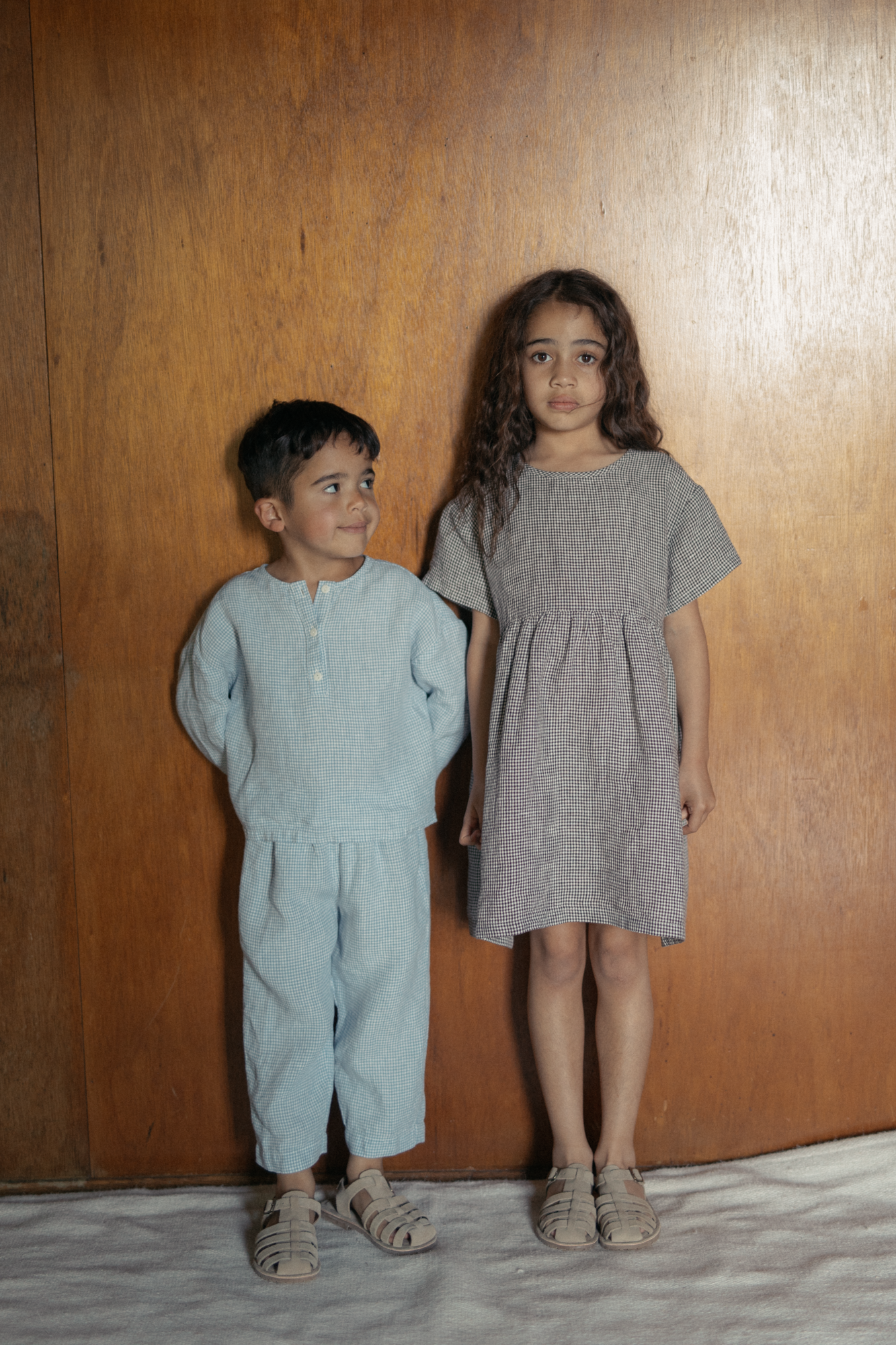 Child wearing the Bertie Pant in Pale Blue Gingham by Gillian Stevens, front view styled with matching top