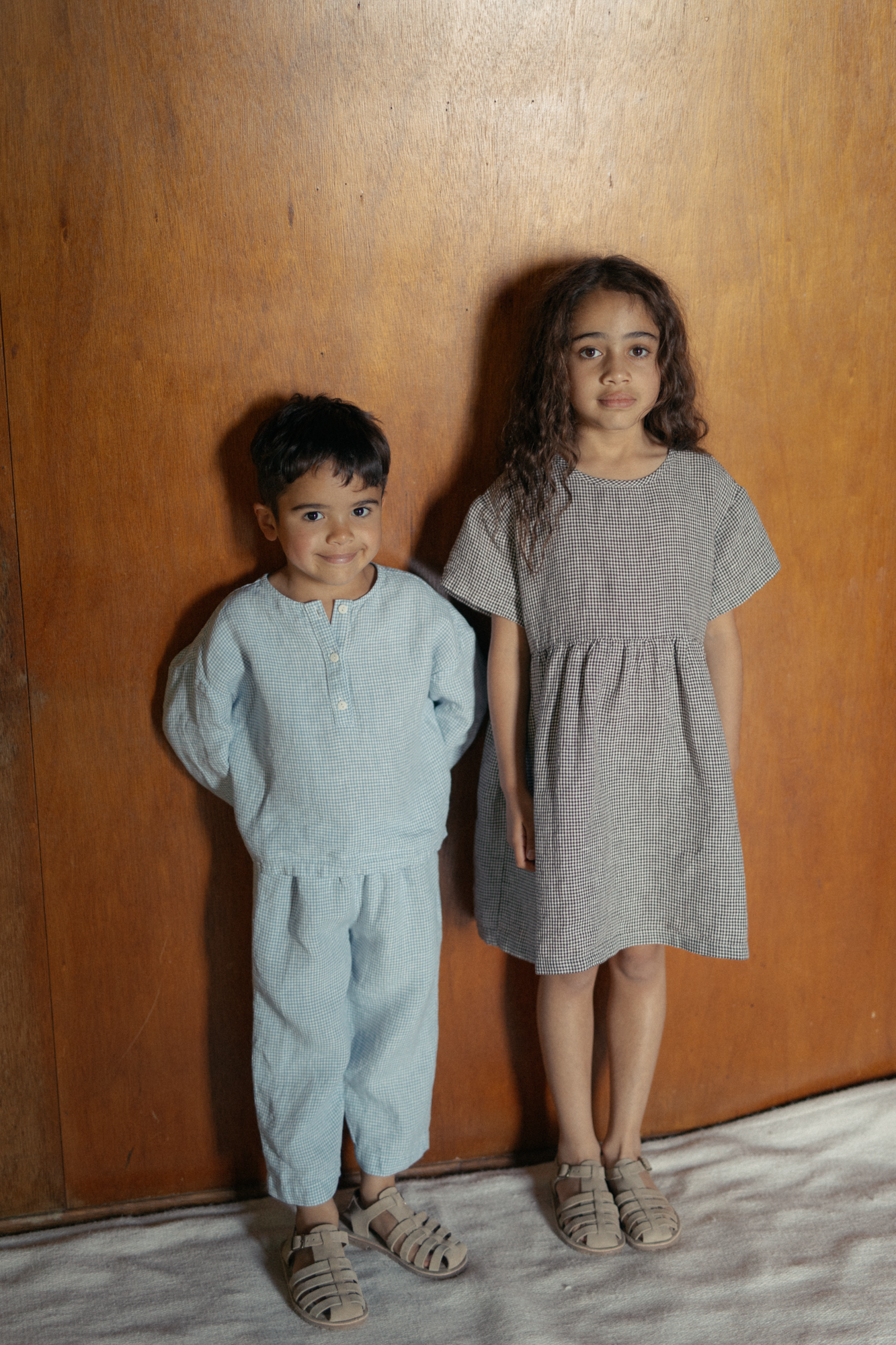 Child wearing the Bertie Top in Pale Blue Gingham by Gillian Stevens, front view styled with matching pants