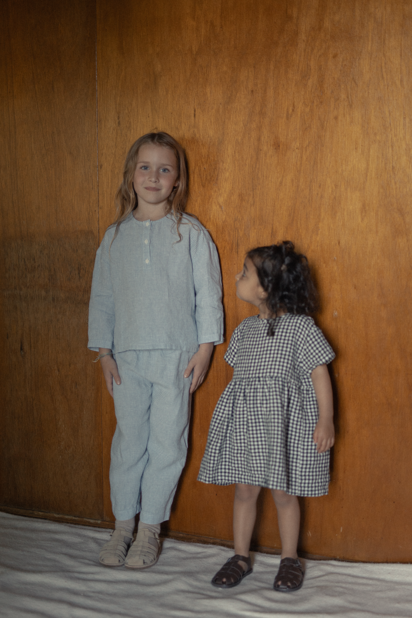 Child wearing the Bertie Top in Pale Blue Gingham by Gillian Stevens, front view styled with matching pants