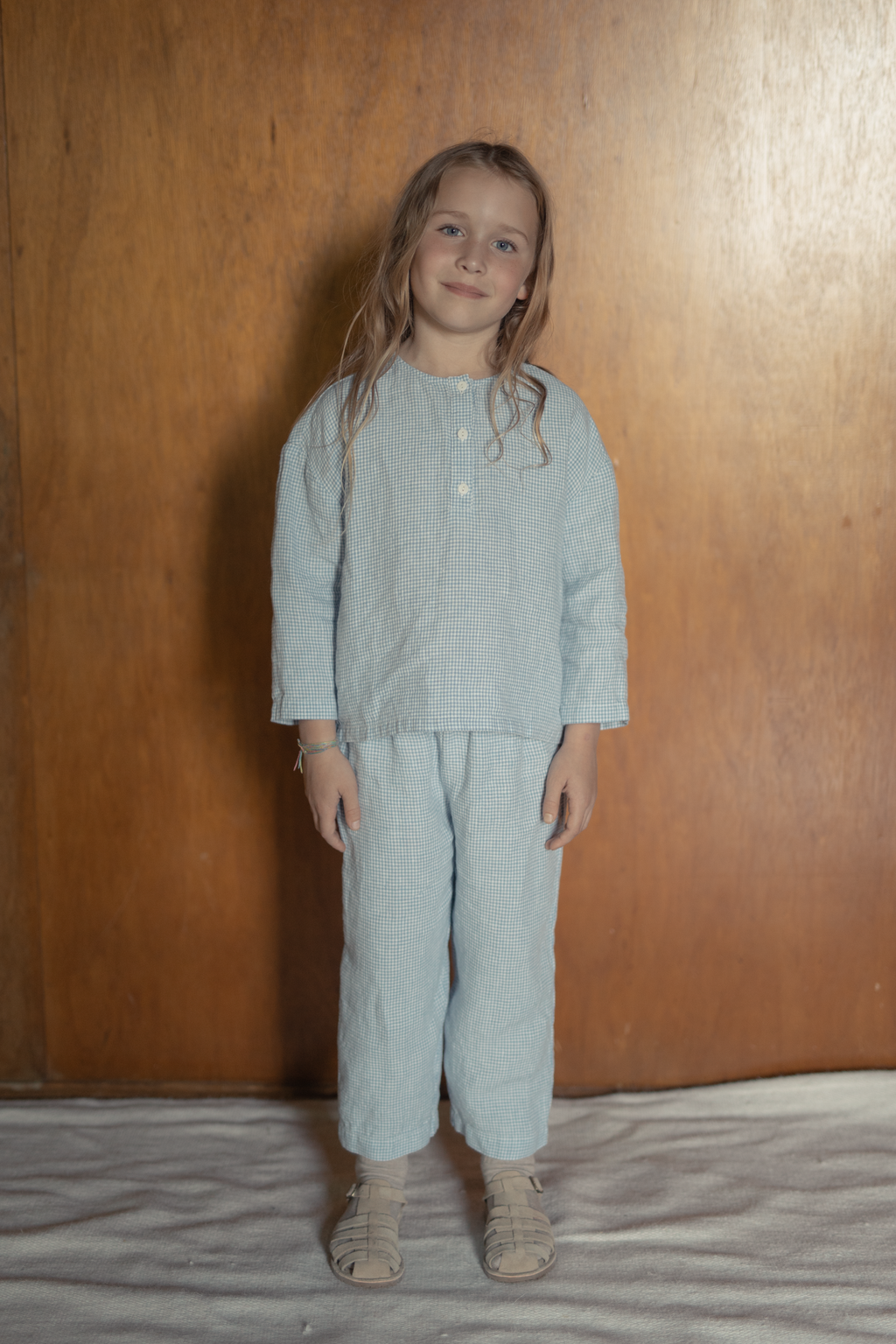 Child wearing the Bertie Pant in Pale Blue Gingham by Gillian Stevens, front view styled as a matching set