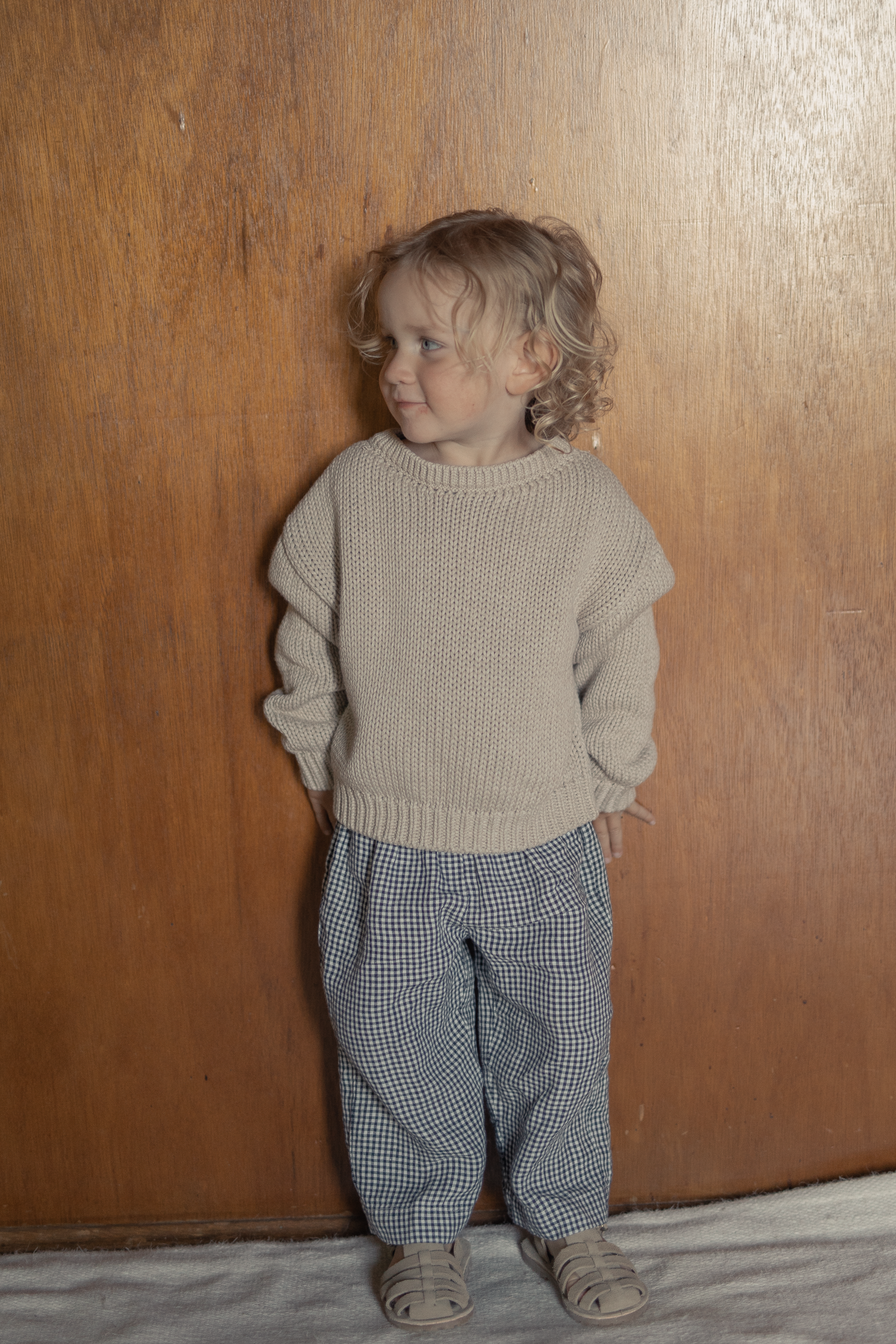 Child wearing the Mini Townes Pullover in Oat by Gillian Stevens, front view with chunky knit texture