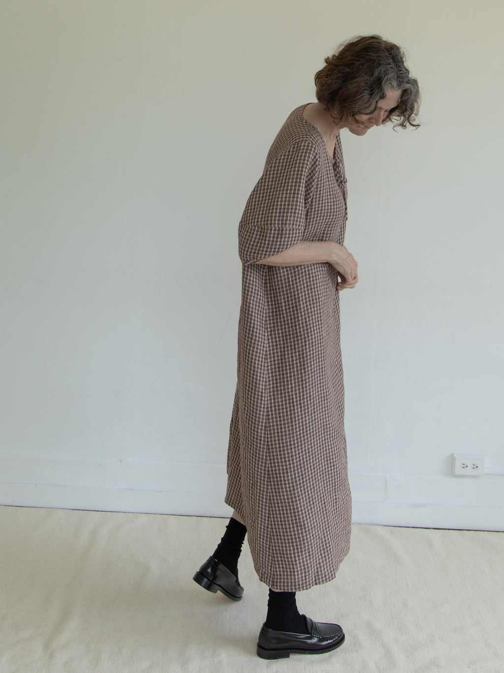 Model wearing the Blair Dress in Chocolate Plaid by Gillian Stevens, side view showing midi length