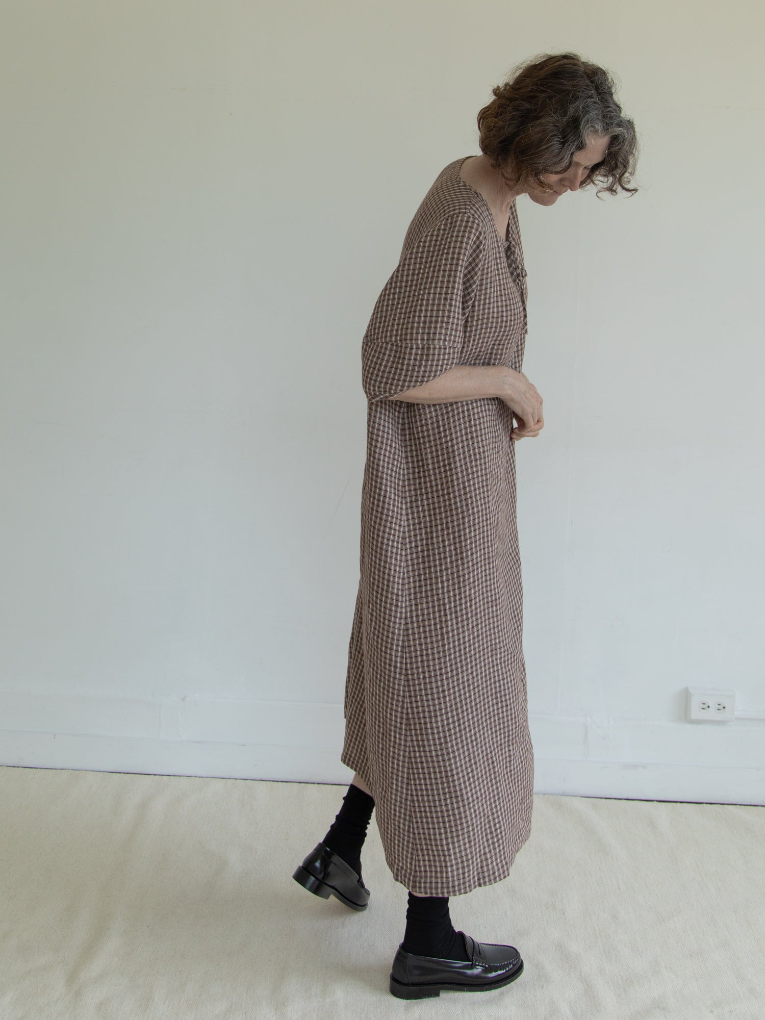 Model wearing the Blair Dress in Chocolate Plaid by Gillian Stevens, side view showing midi length