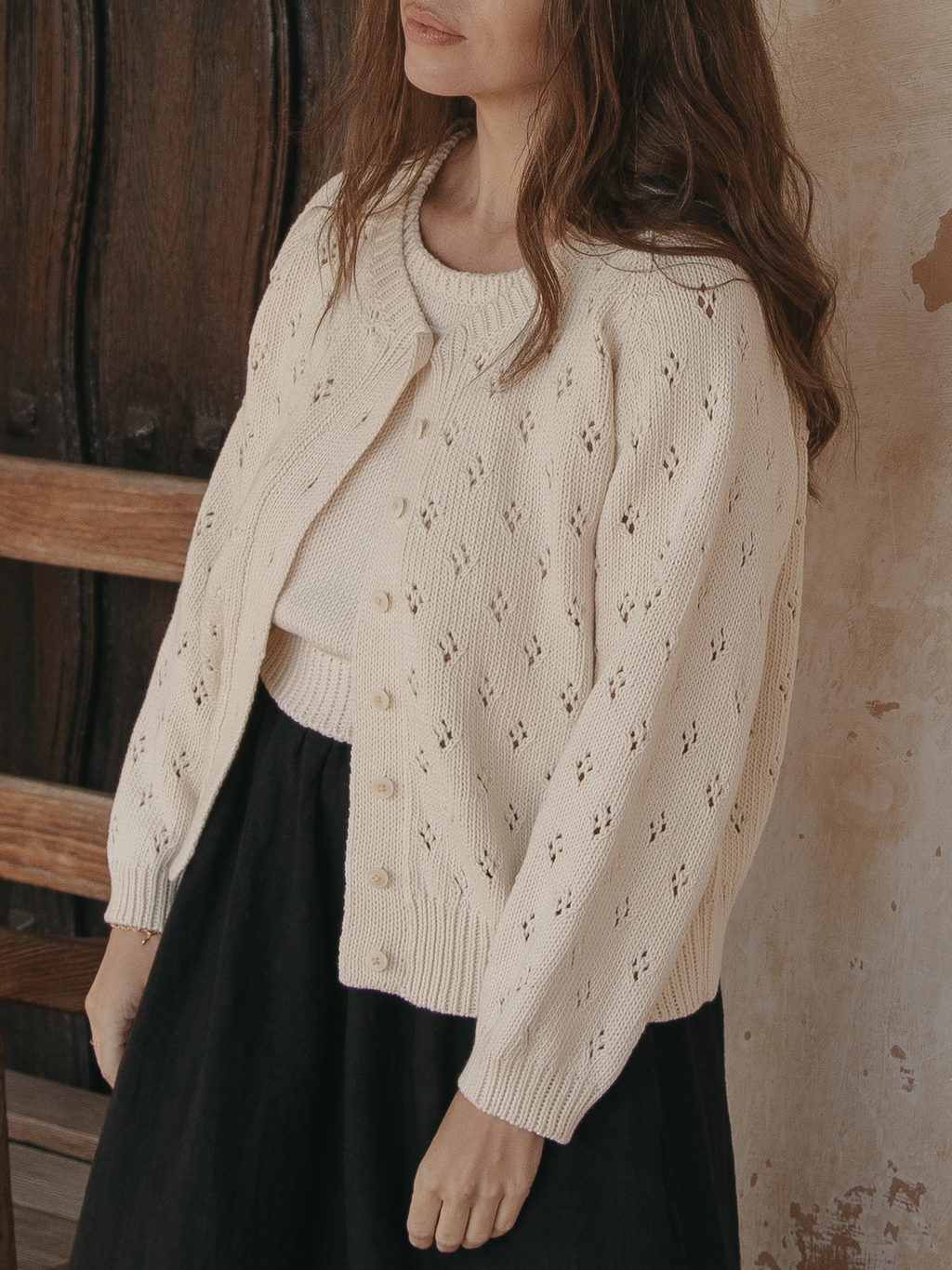 Model wearing the Mabel Cardigan in Ivory by Gillian Stevens, front view showing pointelle detail and buttons, view 2
