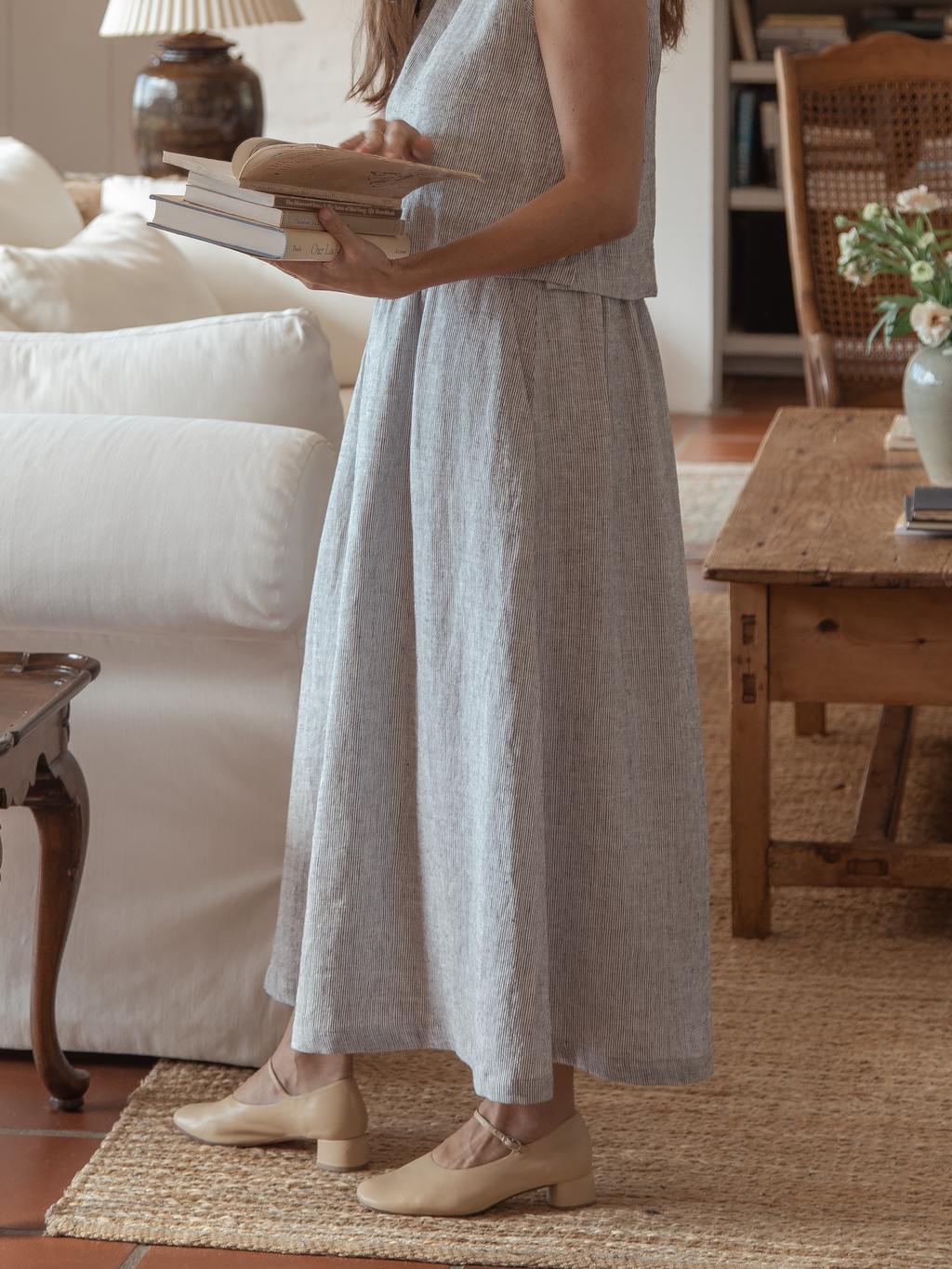 Model wearing the Molly Skirt in Charcoal Stripe by Gillian Stevens, front view in a living room setting