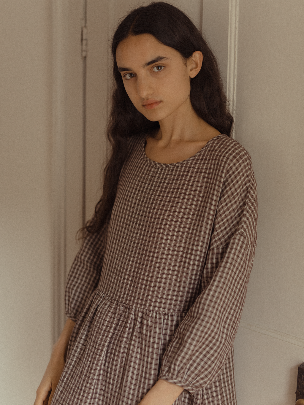 Model wearing the Darla Dress in Chocolate Plaid by Gillian Stevens, angled front view showing dropped waist
