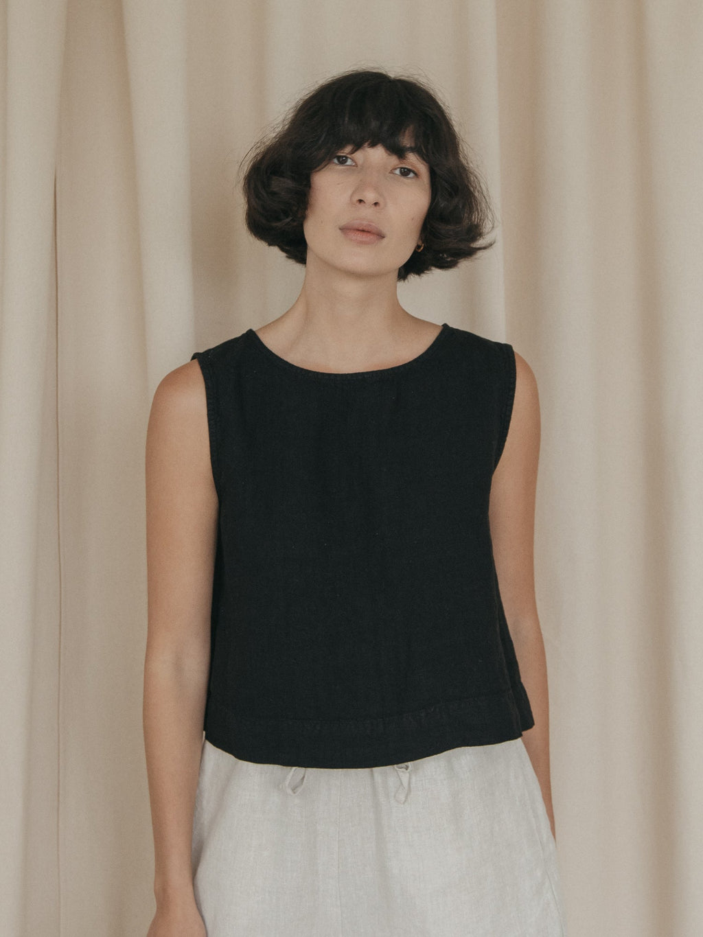 Model wearing the Finley Top in Noir by Gillian Stevens, front view showing scoop neck and sleeveless silhouette