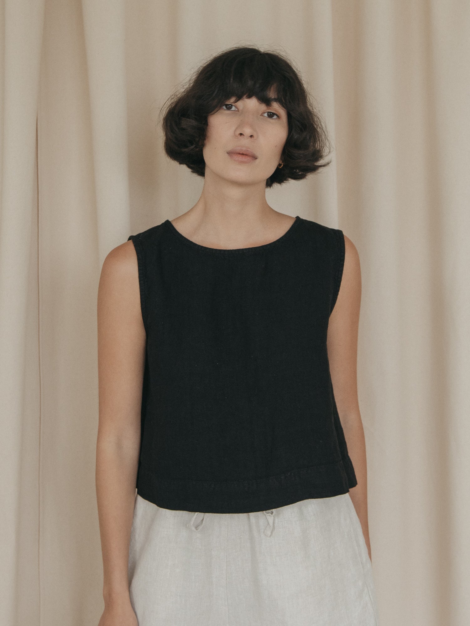 Model wearing the Finley Top in Noir by Gillian Stevens, front view showing scoop neck and sleeveless silhouette