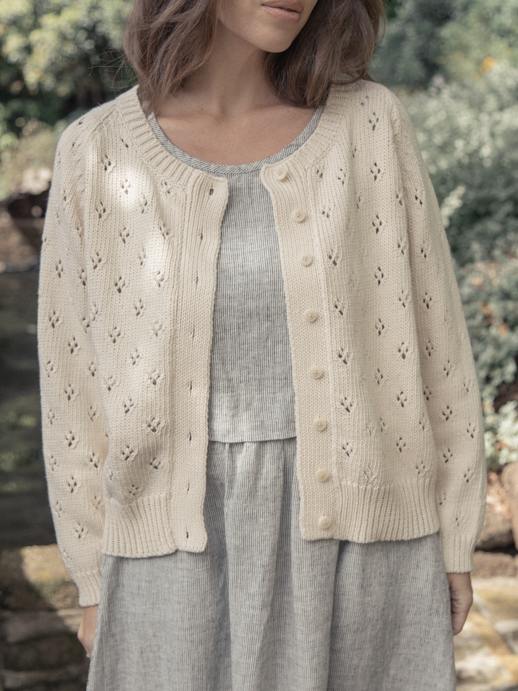 Model wearing the Mabel Cardigan in Ivory by Gillian Stevens, front view showing pointelle detail and buttons