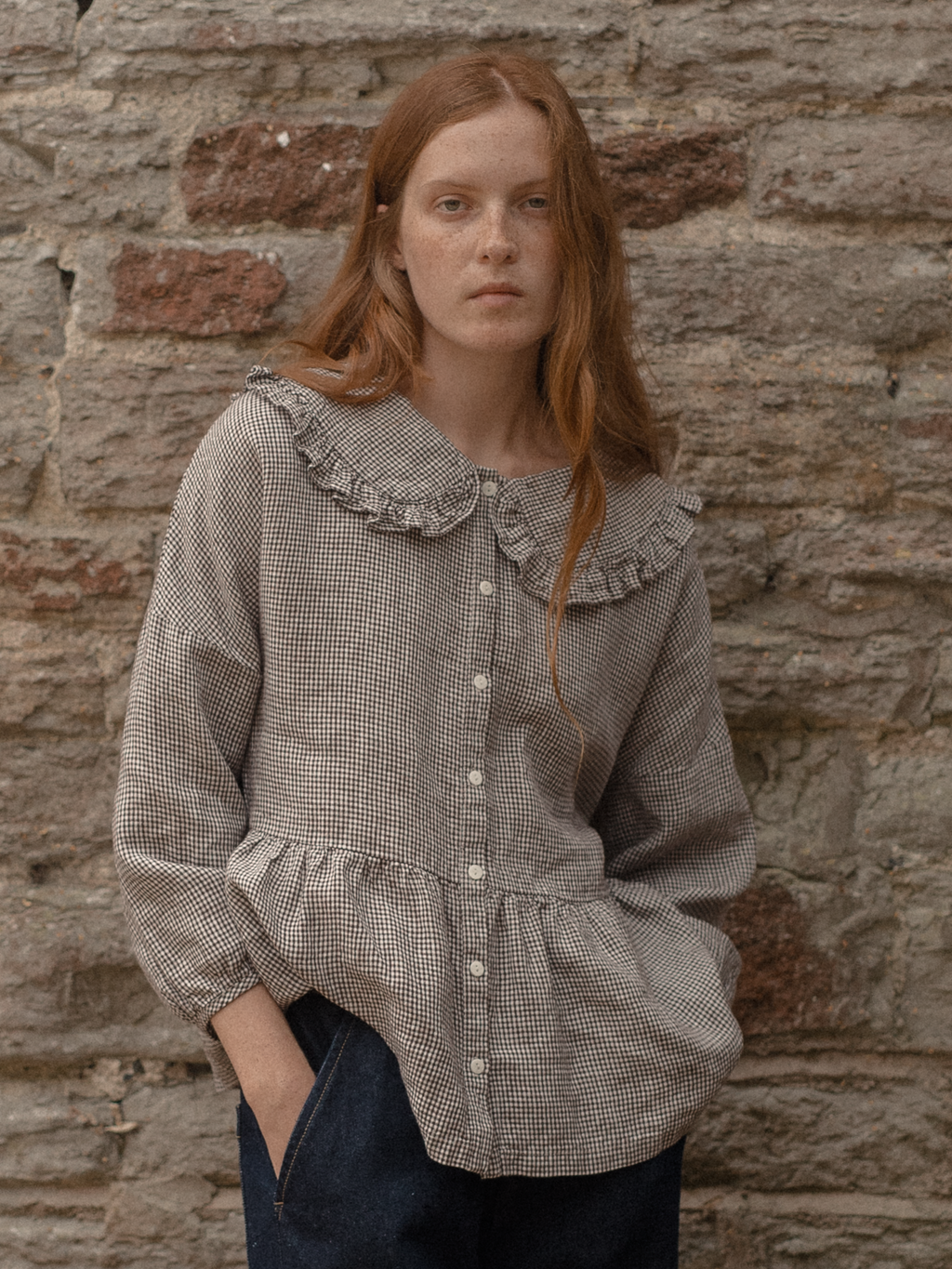 Model wearing the Winsley Blouse in Espresso Gingham by Gillian Stevens, front view showing ruffle collar and peplum hem