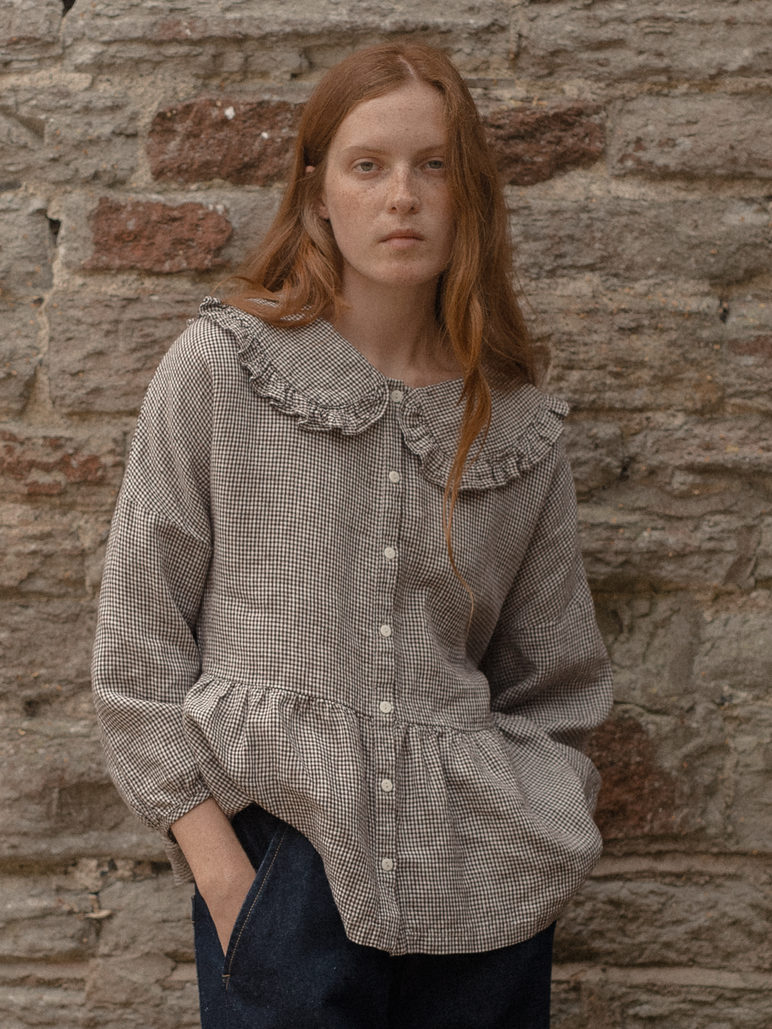 Model wearing the Winsley Blouse in Espresso Gingham by Gillian Stevens, front view showing ruffle collar and peplum hem