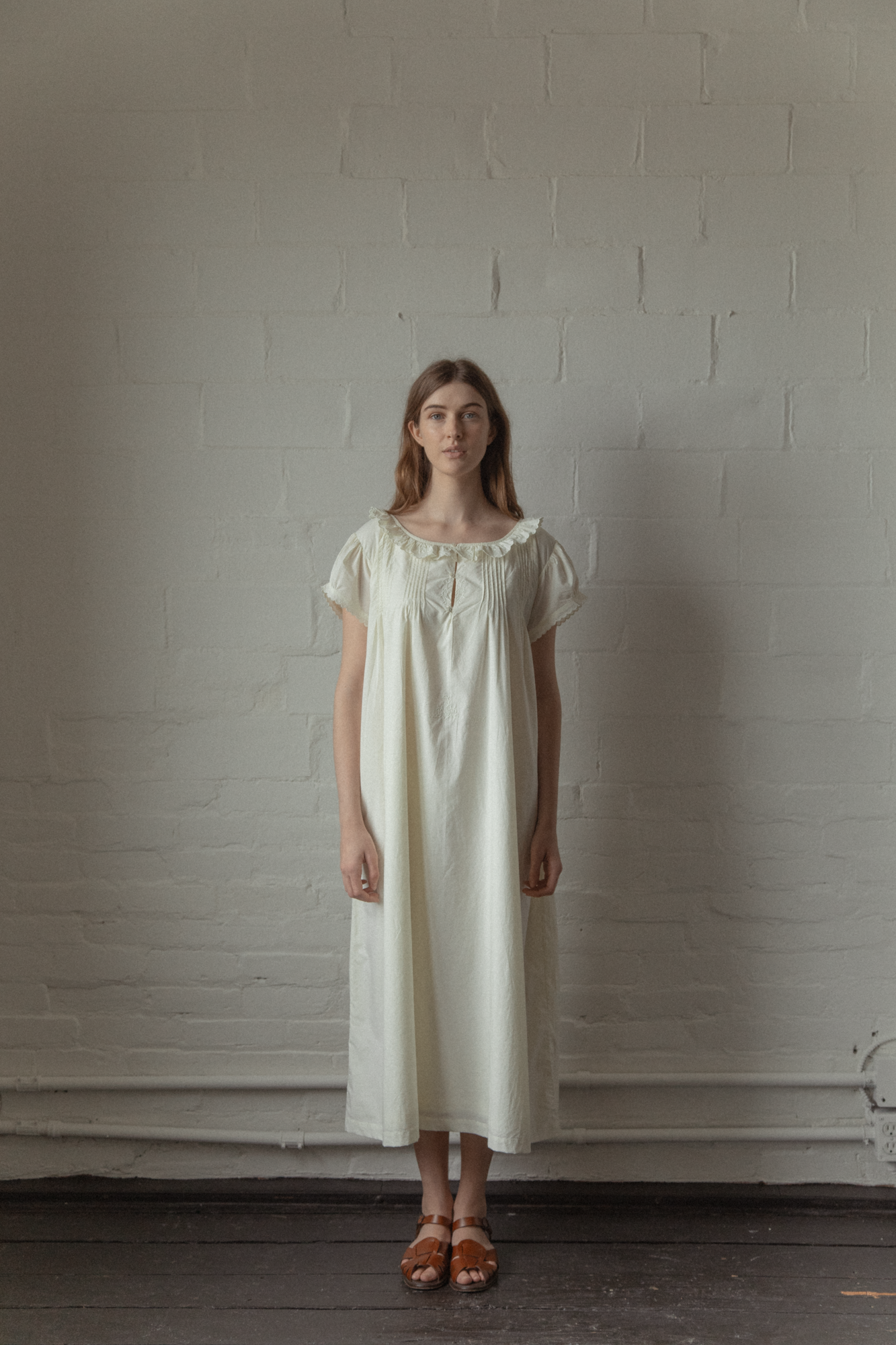 Model wearing the Clover Dress in Butter by Gillian Stevens, front view showing ruffle neckline and pintuck detail