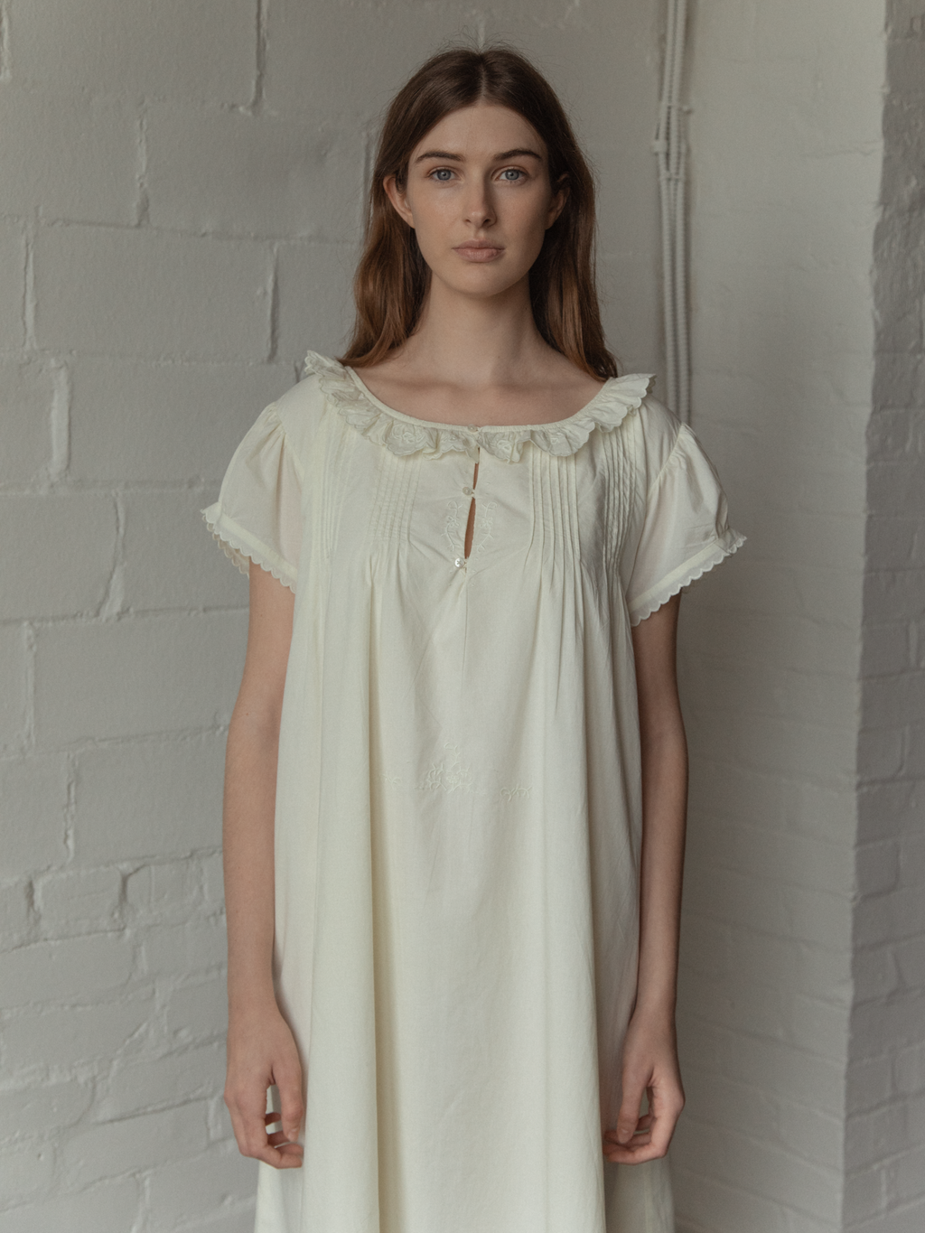 Model wearing the Clover Dress in Butter by Gillian Stevens, front view showing pintuck and ruffle collar detail