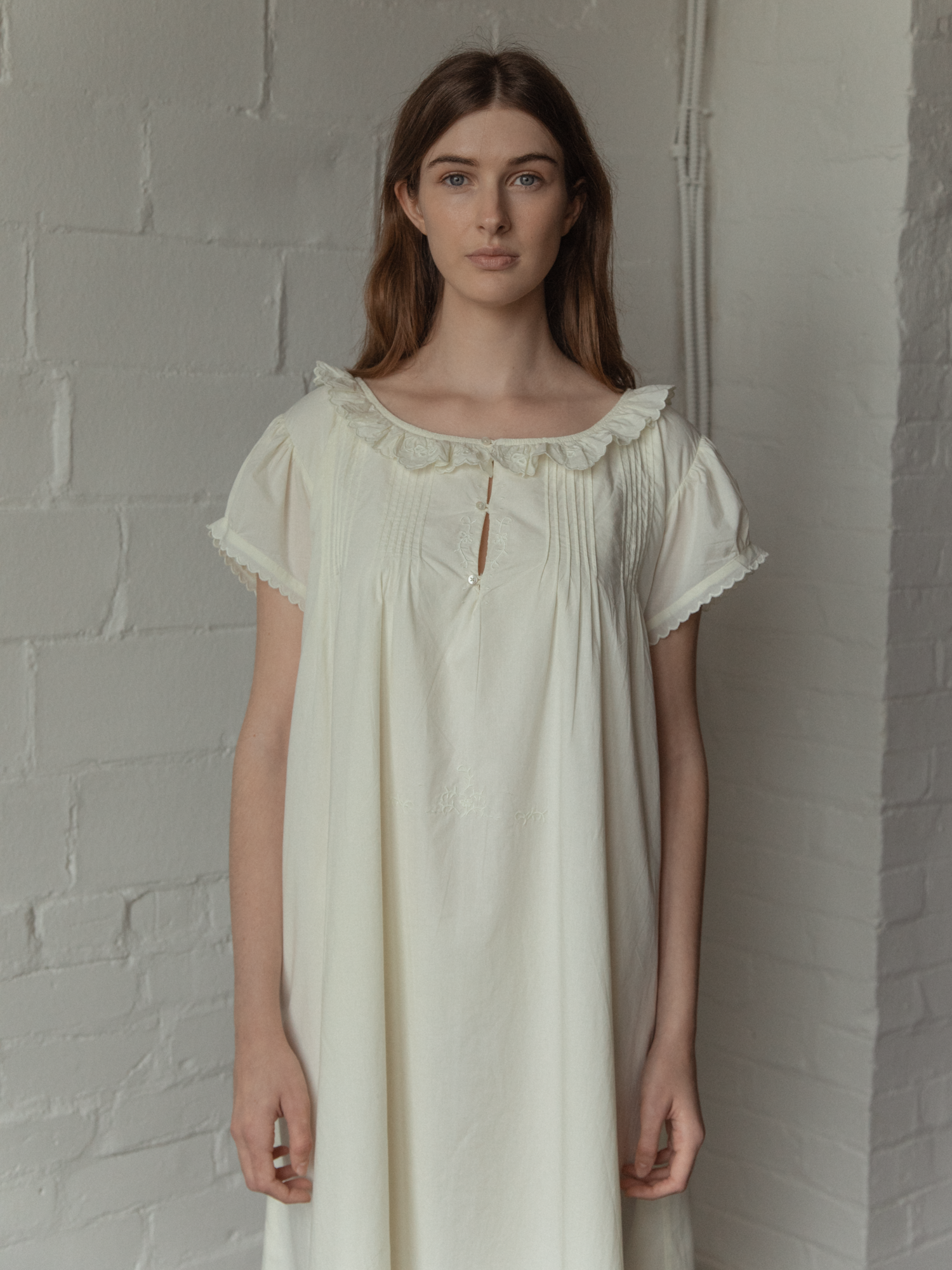 Model wearing the Clover Dress in Butter by Gillian Stevens, front view showing pintuck and ruffle collar detail