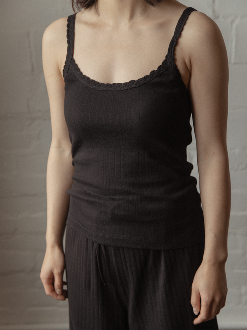 Model wearing the Calla Tank in Noir by Gillian Stevens, front view showing lace trim detail