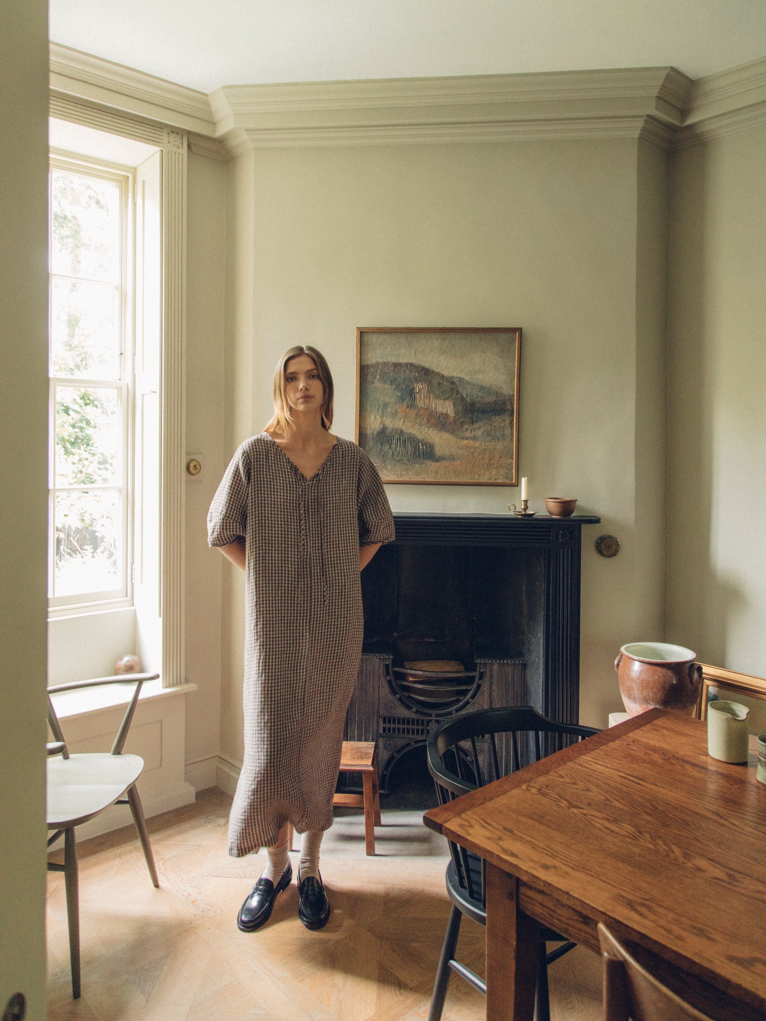 Model wearing the Blair Dress in Chocolate Plaid by Gillian Stevens, full-length front view in a heritage interior setting