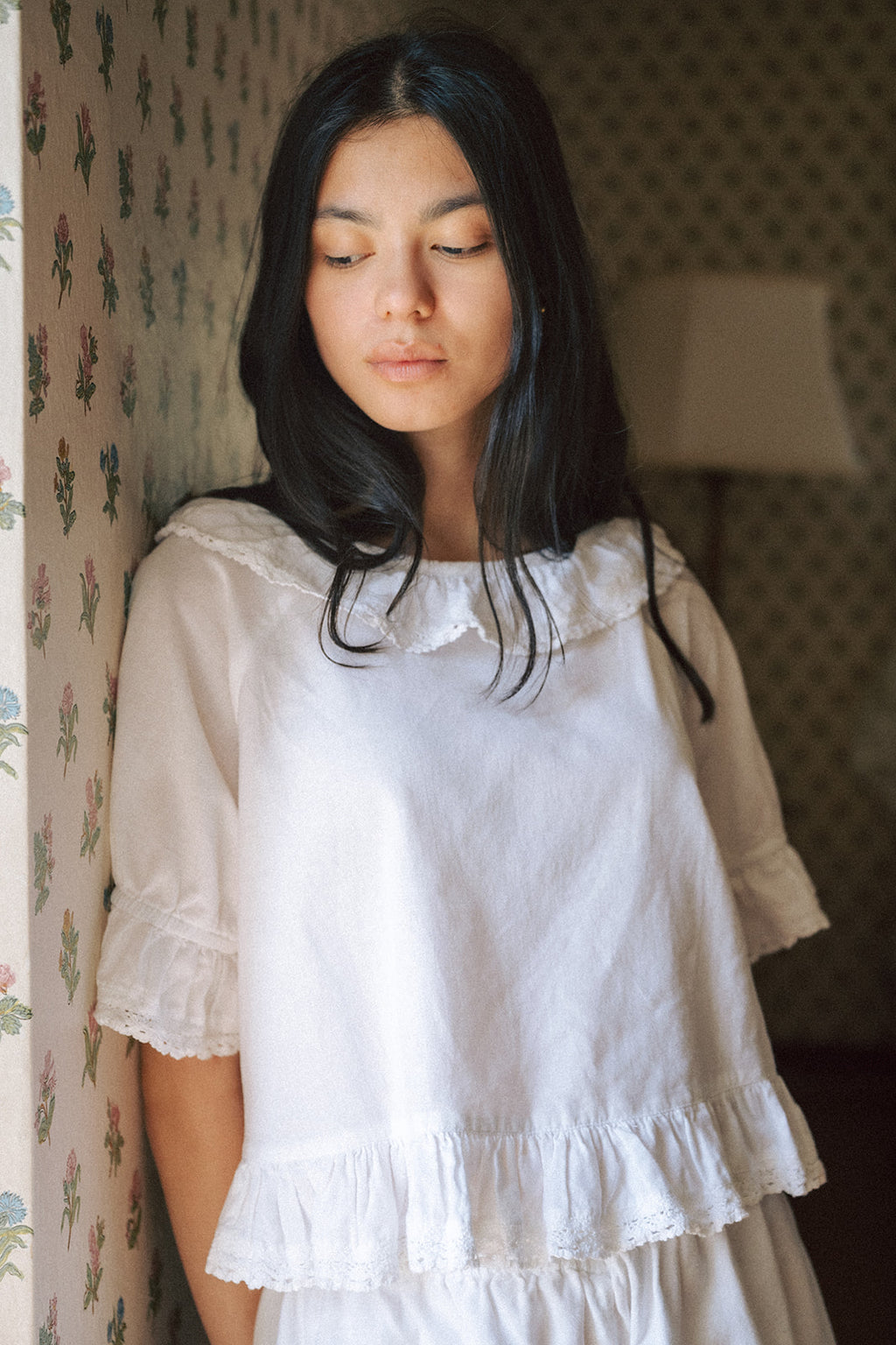 Model wearing the Arlette Top in Salt by Gillian Stevens, front view showing lace collar and ruffle hem detail