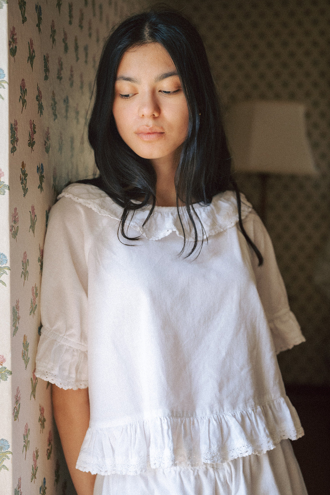 Model wearing the Arlette Top in Salt by Gillian Stevens, front view showing lace collar and ruffle hem detail