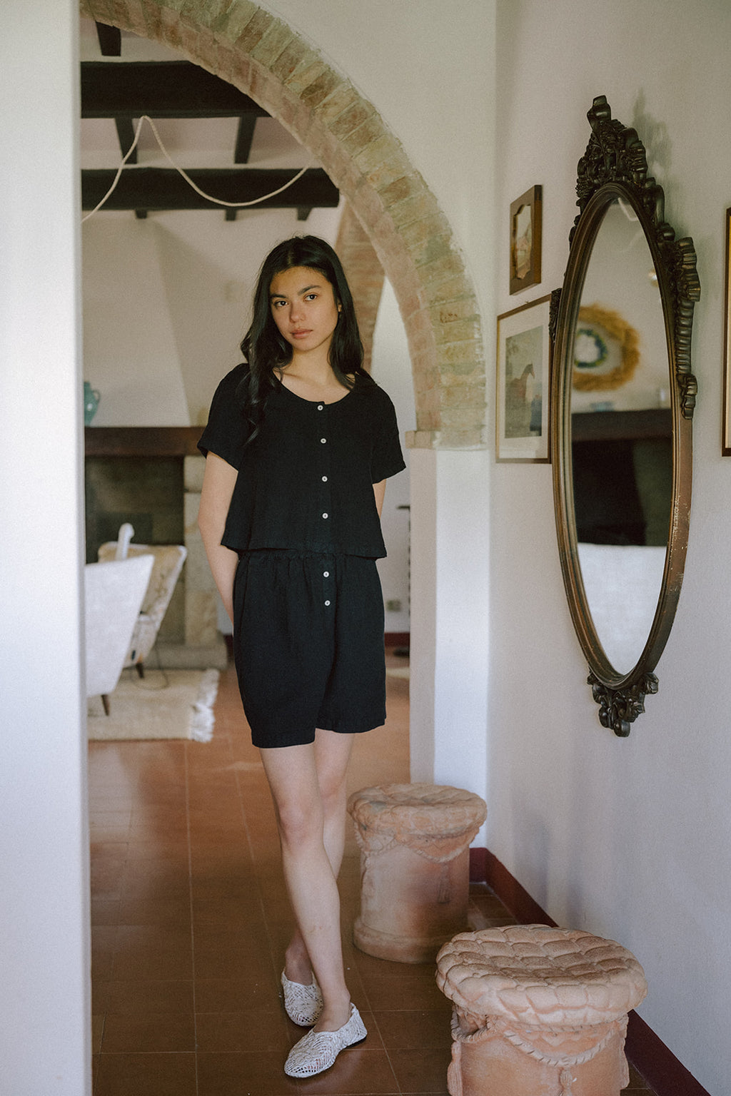 Model wearing the Wren Top in Noir by Gillian Stevens, front view styled with matching black shorts