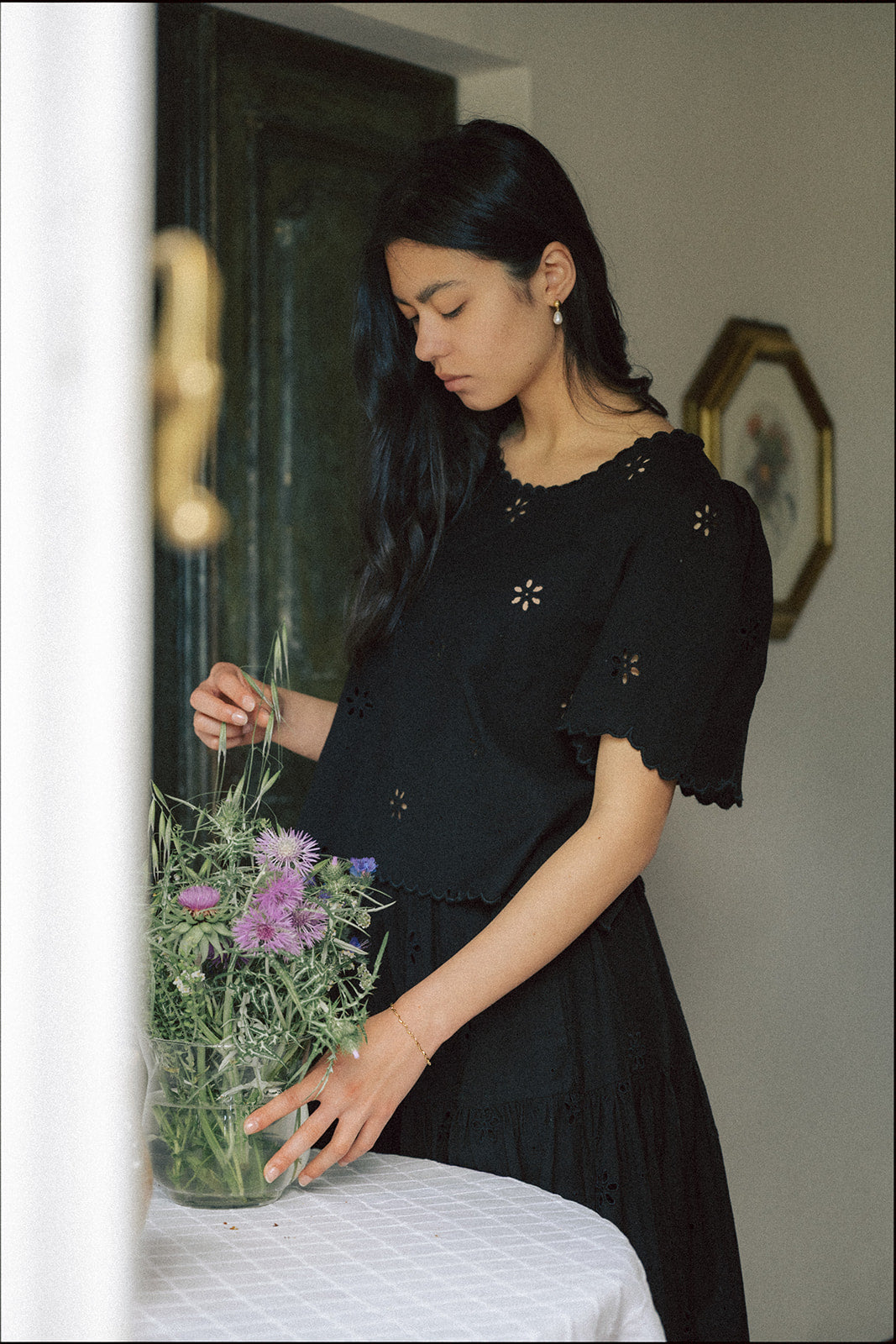 Model wearing the Stella Top in Noir by Gillian Stevens, front view showing eyelet detail and scalloped hem