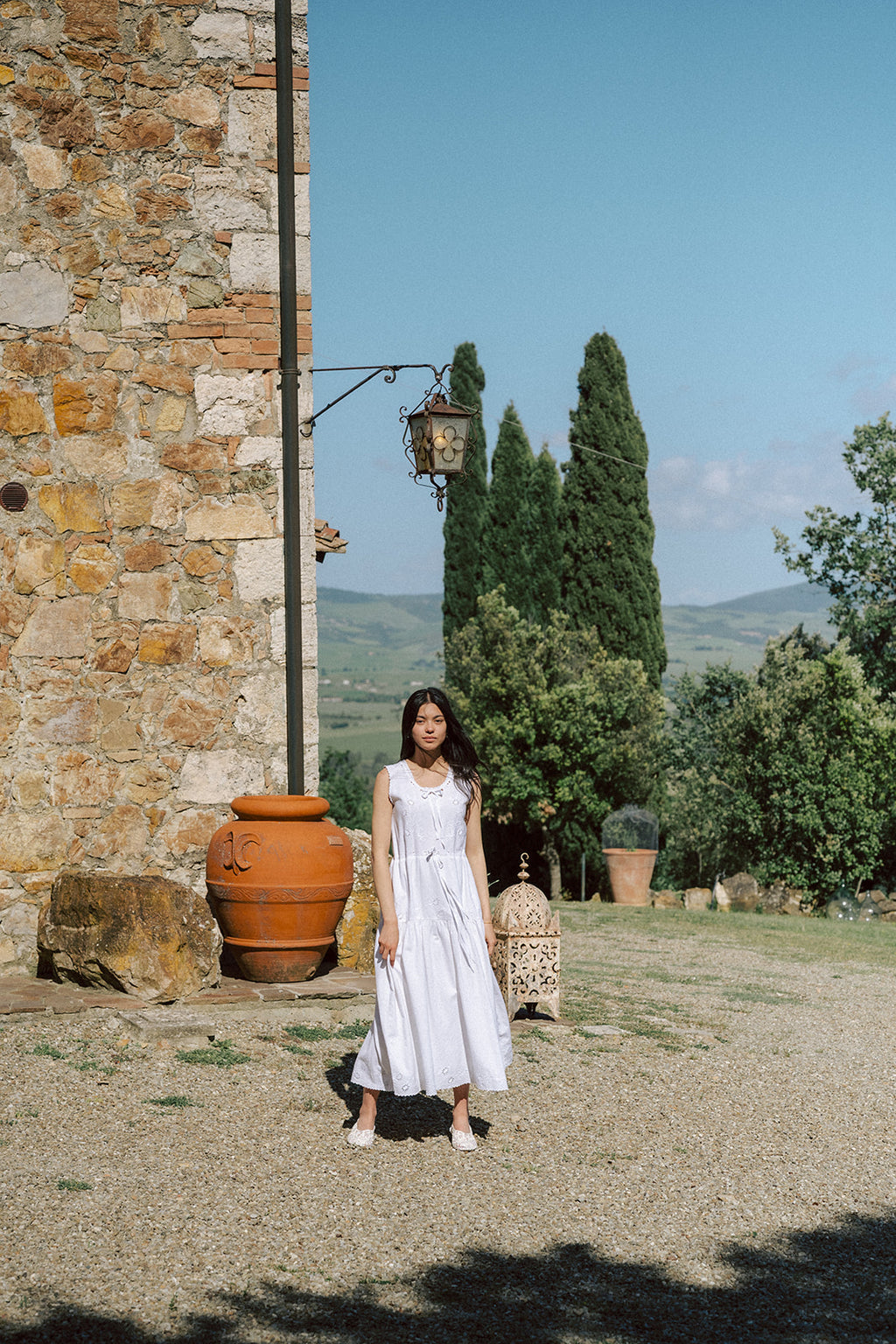 Model wearing the Plum Dress in Salt by Gillian Stevens, full-length front view at a Tuscan estate