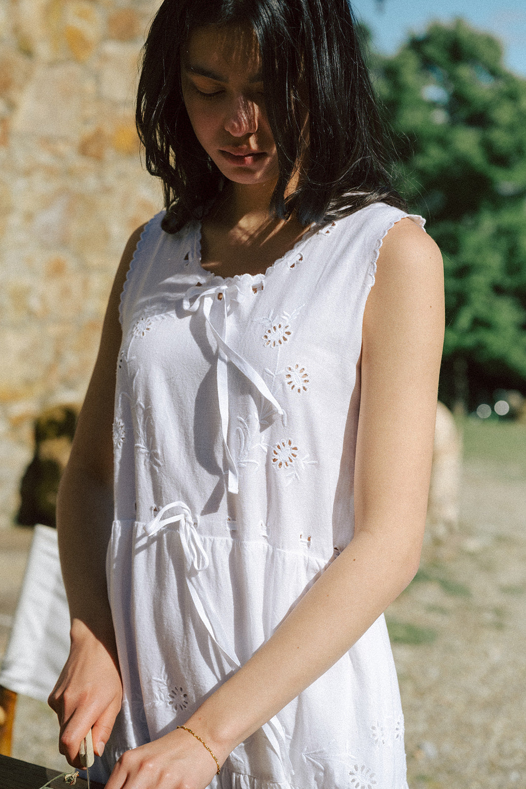Model wearing the Plum Dress in Salt by Gillian Stevens, close-up showing broderie detail and tie neckline