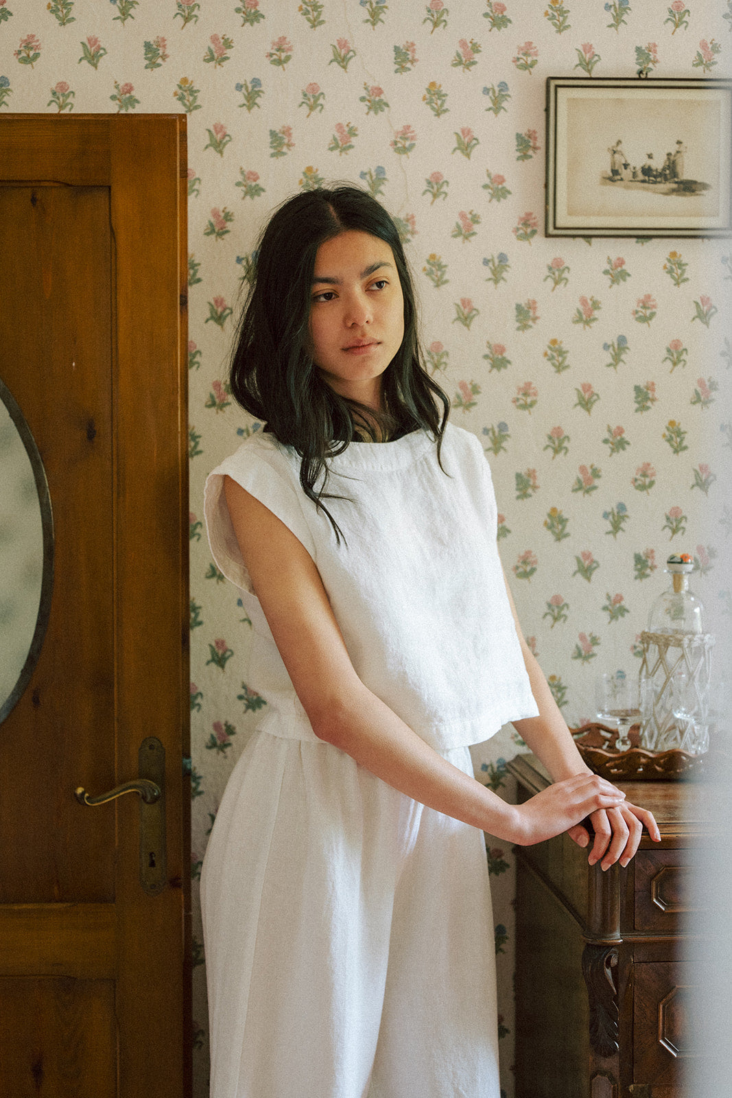 Model wearing the Valley Top in Salt by Gillian Stevens, three-quarter view in a vintage-styled room