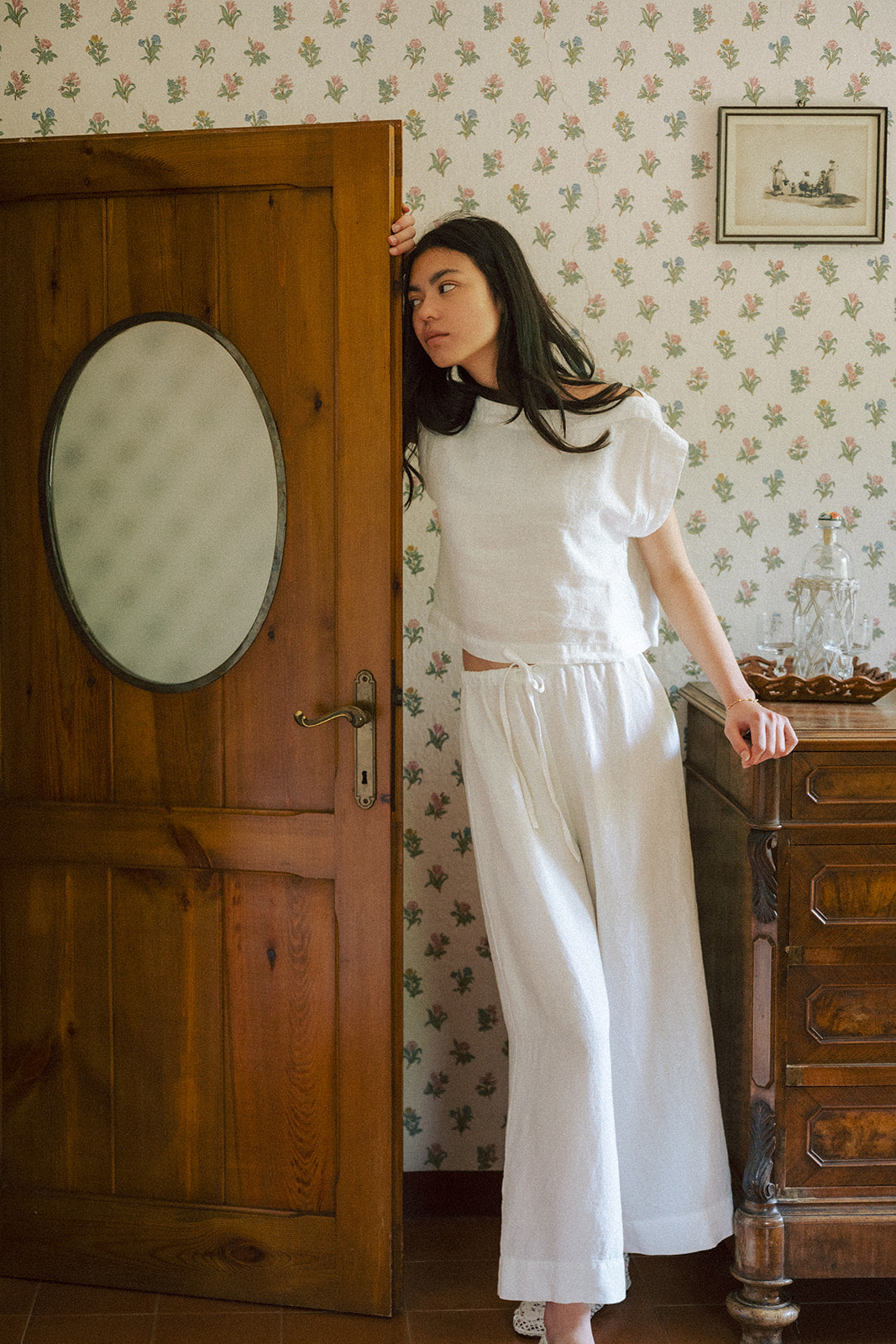 Model wearing the Valley Top in Salt by Gillian Stevens, styled with wide-leg trousers in a vintage-styled room