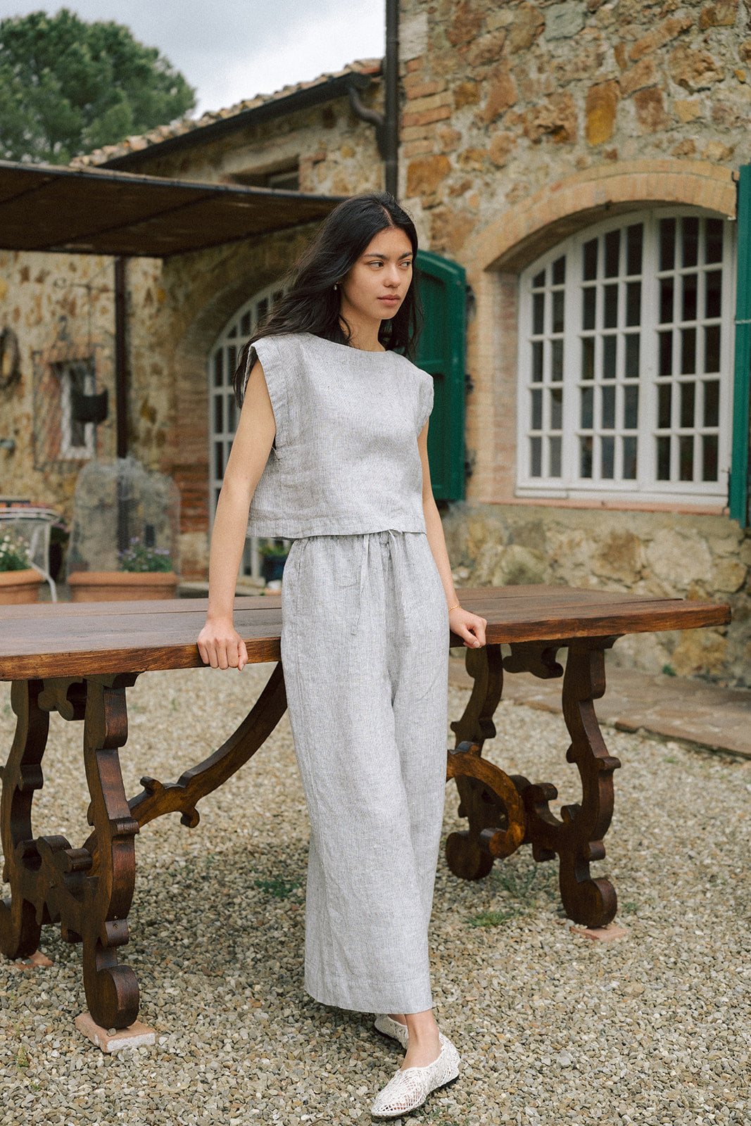 Model wearing the Ines Pant in Charcoal Stripe by Gillian Stevens, full-length front view at rustic outdoor setting