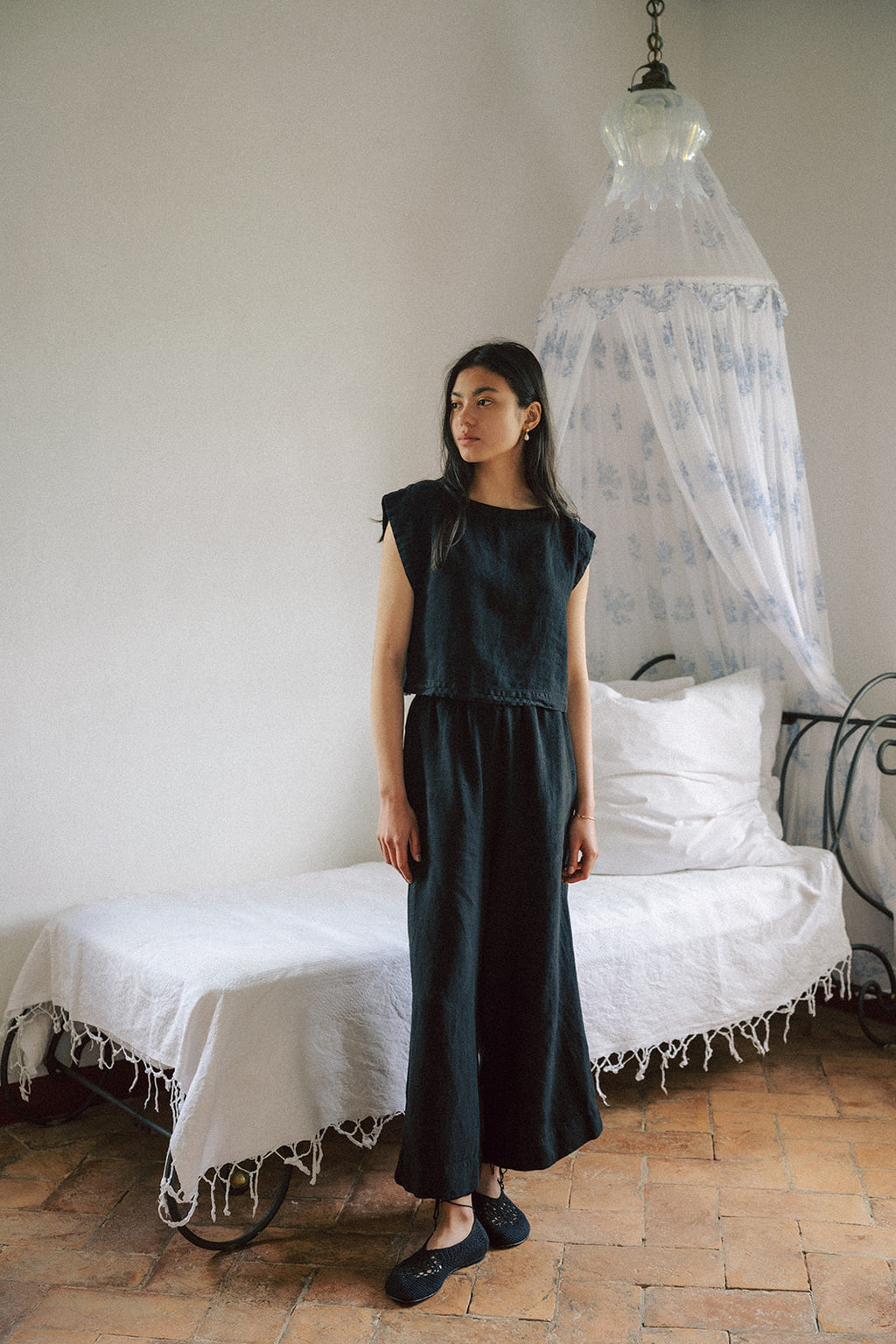 Model wearing the Ines Pant in Noir by Gillian Stevens, full-length front view styled with matching top