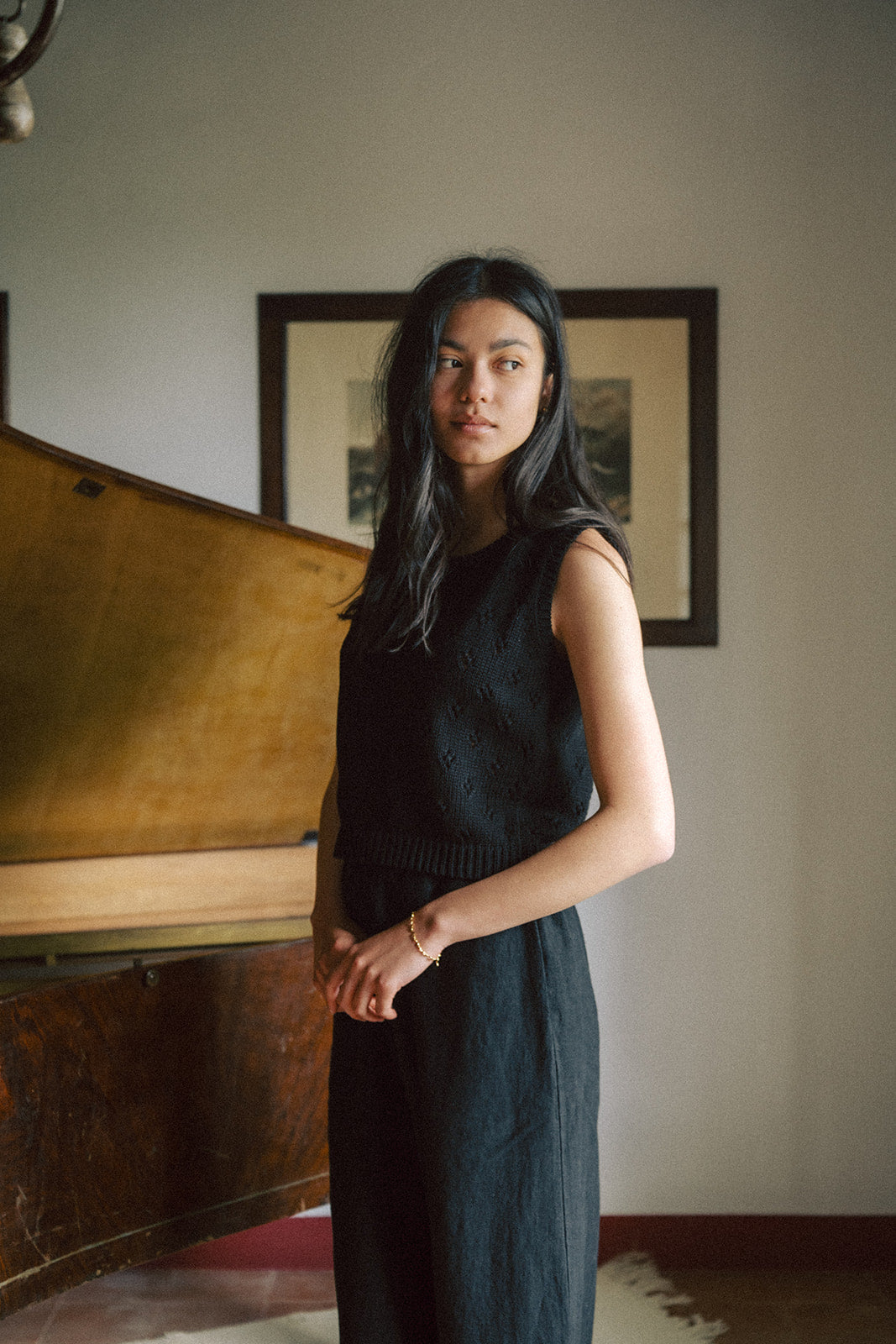 Model wearing the Niah Top in Noir by Gillian Stevens, three-quarter view in an interior setting