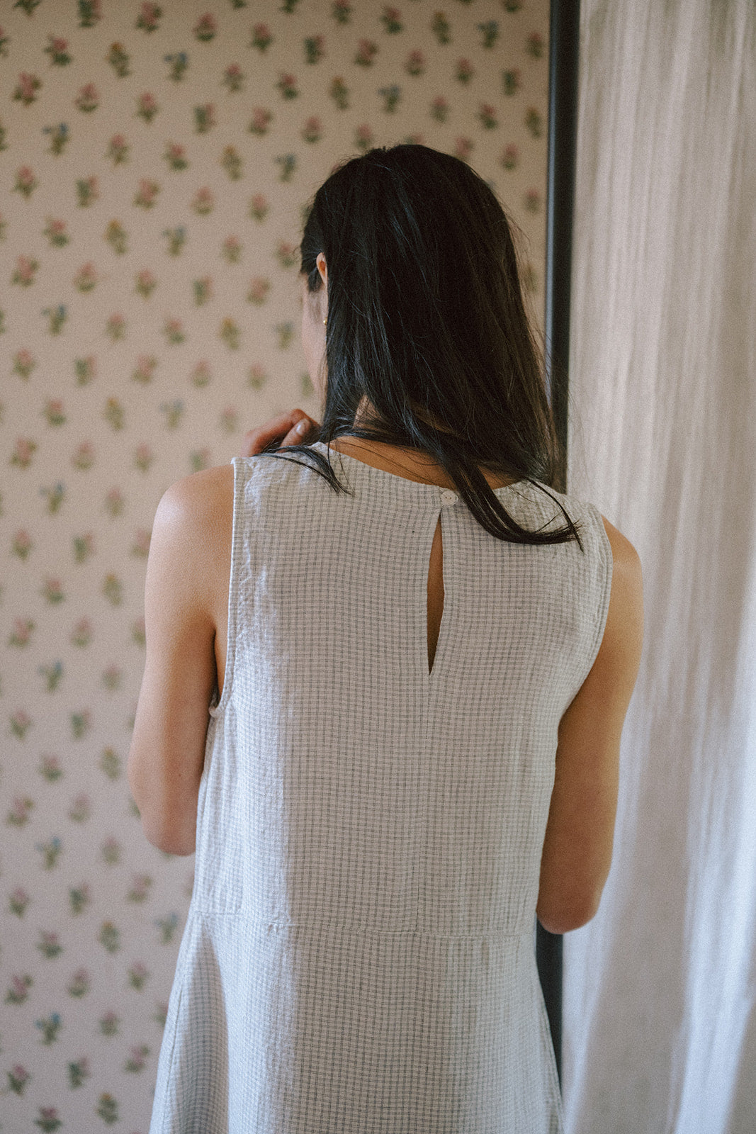 Model wearing the Paige Dress in Dusty Blue Plaid by Gillian Stevens, back view showing keyhole neckline detail