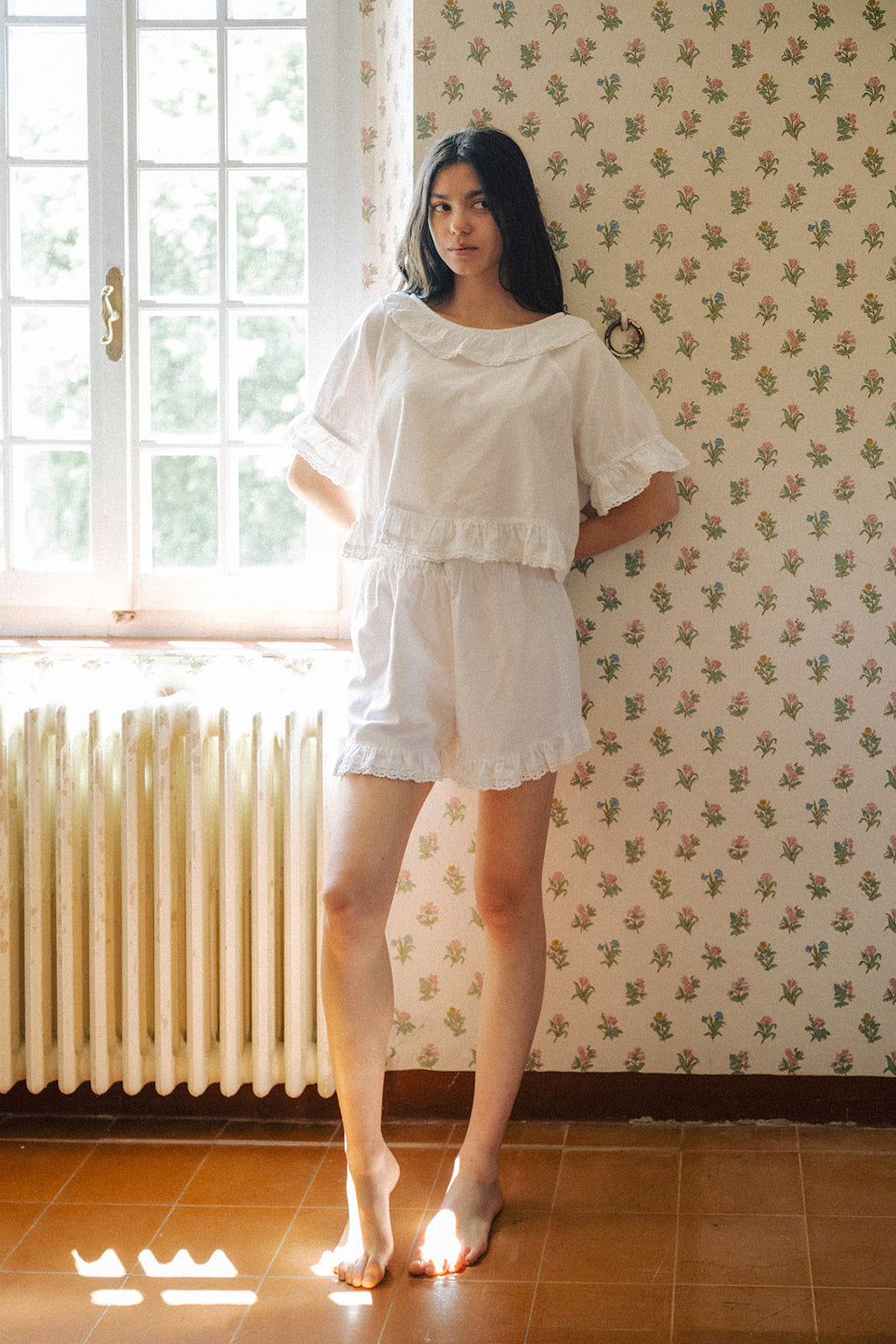 Model wearing the Arlette Short in Salt by Gillian Stevens, front view styled with matching top in a vintage floral room