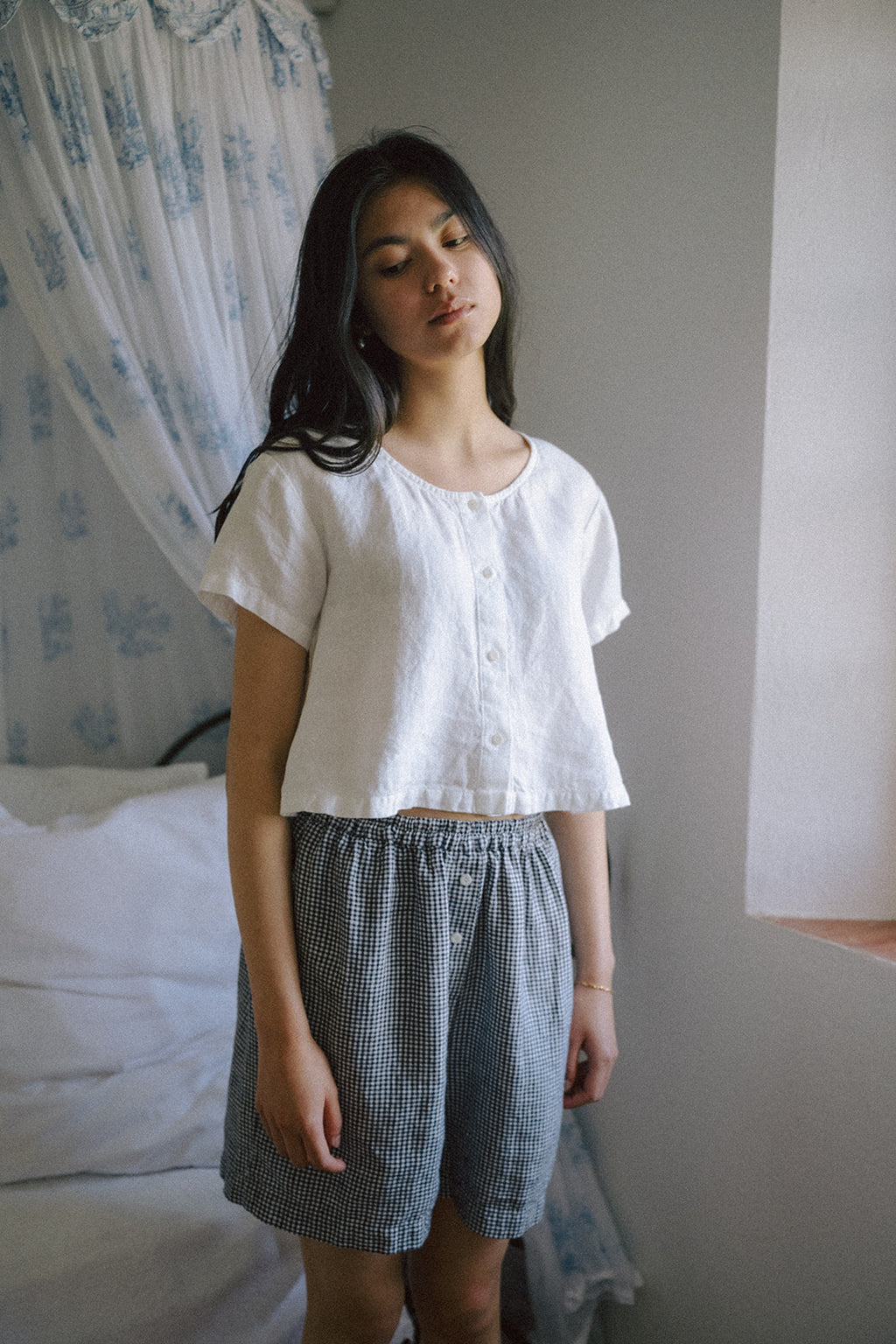 Model wearing the Wren Top in Salt by Gillian Stevens, front view styled with gingham shorts