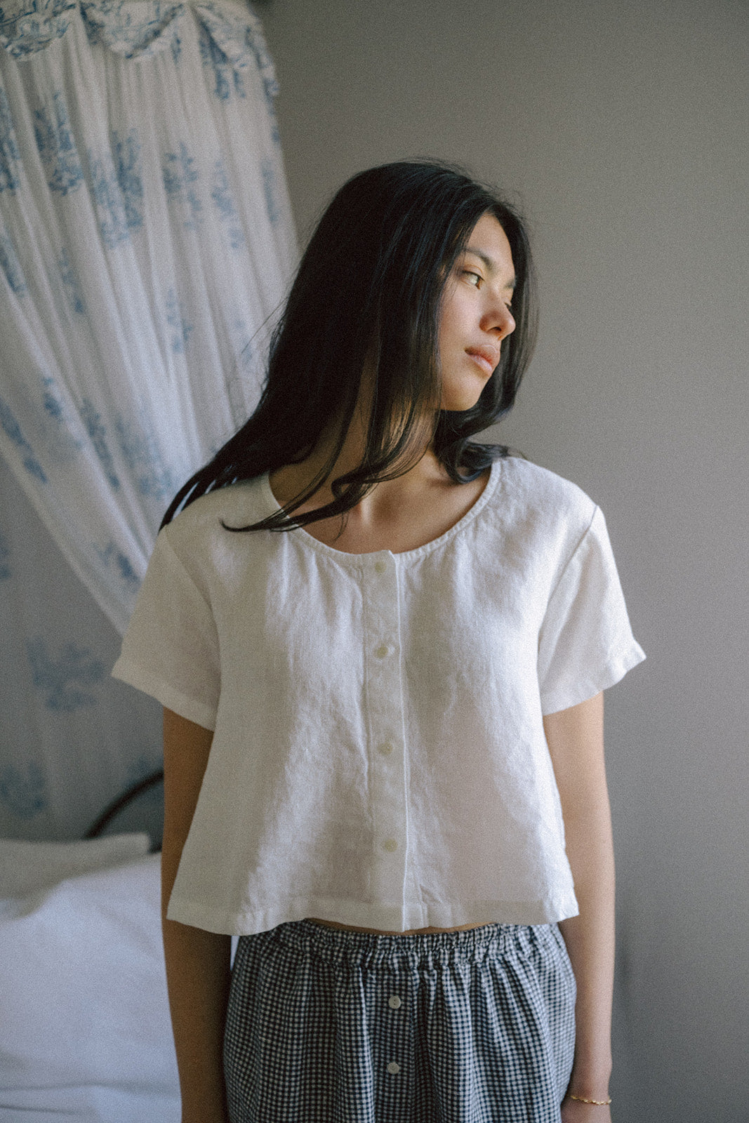 Model wearing the Wren Top in Salt by Gillian Stevens, front view showing button placket and cropped linen silhouette